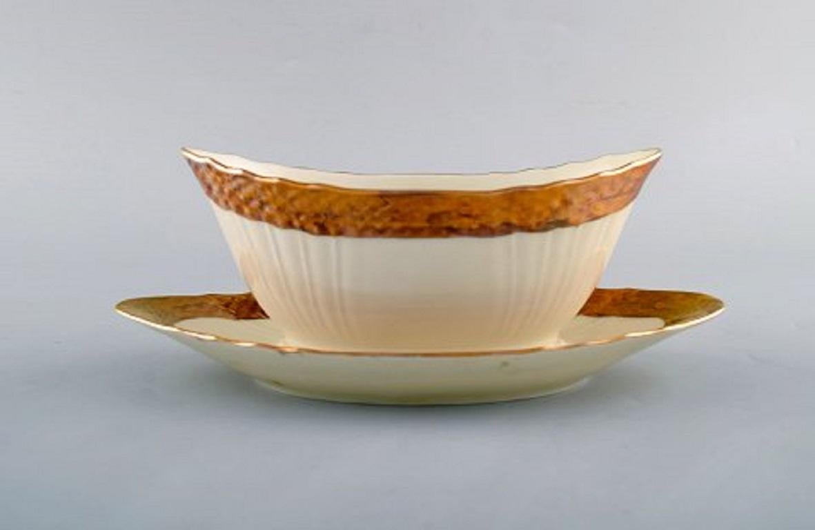 Royal Copenhagen porcelain sauce boat with floral motifs and gold border, mid-20th century. Two pieces in stock.
Measures: 23 x 9 cm.
In very good condition.
Stamped.
2nd factory quality.