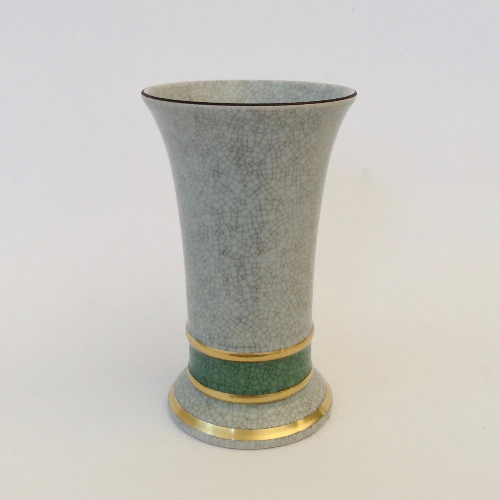 Royal Copenhagen vase, circa 1950, Denmark.
Light blue grey crackle glaze porcelain with green and gold details.
Stamped and numbered underneath.
Dimensions: 14 cm Height, 9 cm diameter.
All purchases are covered by our Buyer Protection