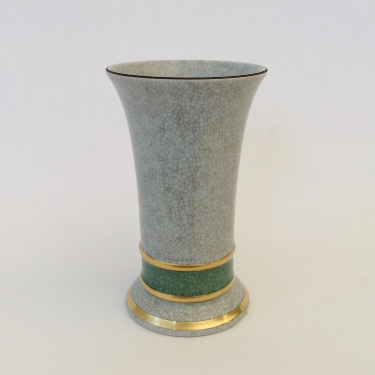 Royal Copenhagen vase, circa 1950, Denmark.
Light blue grey crackle glaze porcelain with green and gold details.
Stamped and numbered underneath.
Dimensions: 14 cm Height, 9 cm diameter.
All purchases are covered by our Buyer Protection