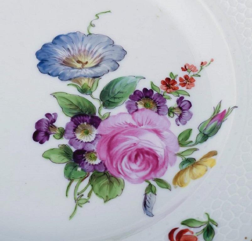 Flor Sachian de Royal Copenhagen. 
Cuatro platos llanos con flores pintadas a mano y decoración dorada. Aproximadamente 1900.
Model No. 213/2028
Medidas: 25,0 cm. x 3,5 cm.
En buen estado, con desportilladuras insignificantes en el
