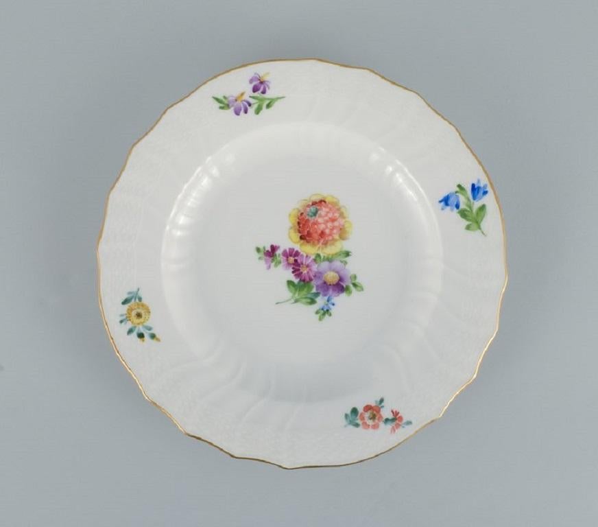 Royal Copenhagen Sächsische Blume. 
Fünf Essteller aus handbemaltem Porzellan mit Blumen und Golddekor.
Modellnummer 493/1621.
In ausgezeichnetem Zustand.
Markiert.
Zweite Fabrikqualität.
Abmessungen: D 25,0 x H 3,0 cm.