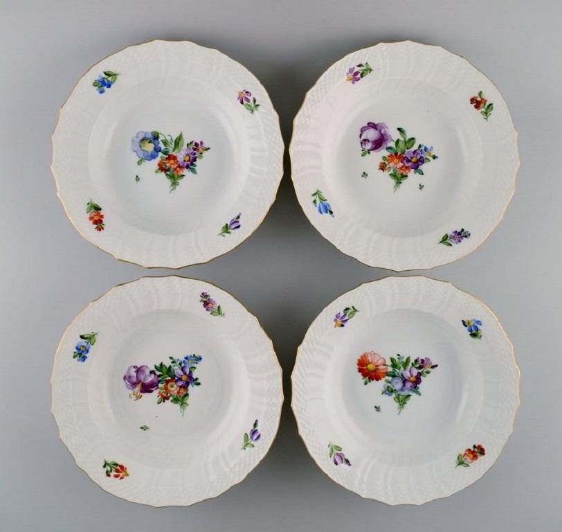 Royal Copenhagen Saxon Flower. Seven deep plates in hand-painted porcelain with flowers and gold decoration. 
Model number 493/1615. 
Early 20th century.
Measures: 23.5 x 5 cm.
In excellent condition.
Stamped.
2nd factory quality.
