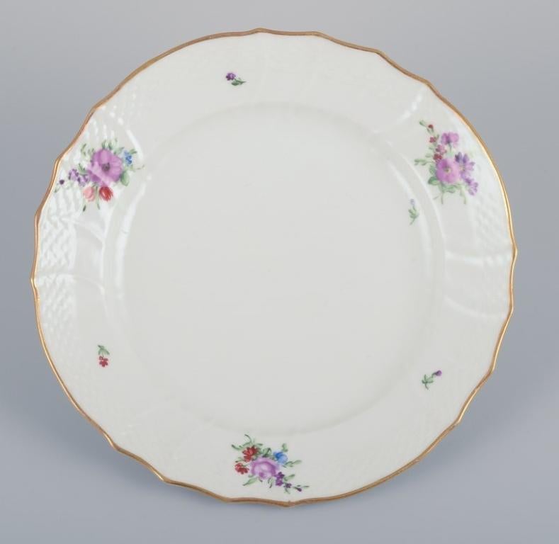 Royal Copenhagen Saxon Flower. Six lunch plates in porcelain. 
Hand-painted with polychrome flowers. Gold rim.
Model: 482/1623.
Early 1900s.
Marked.
In perfect condition.
Second factory quality.
Dimensions: D 22.0 cm x H 3.0 cm.