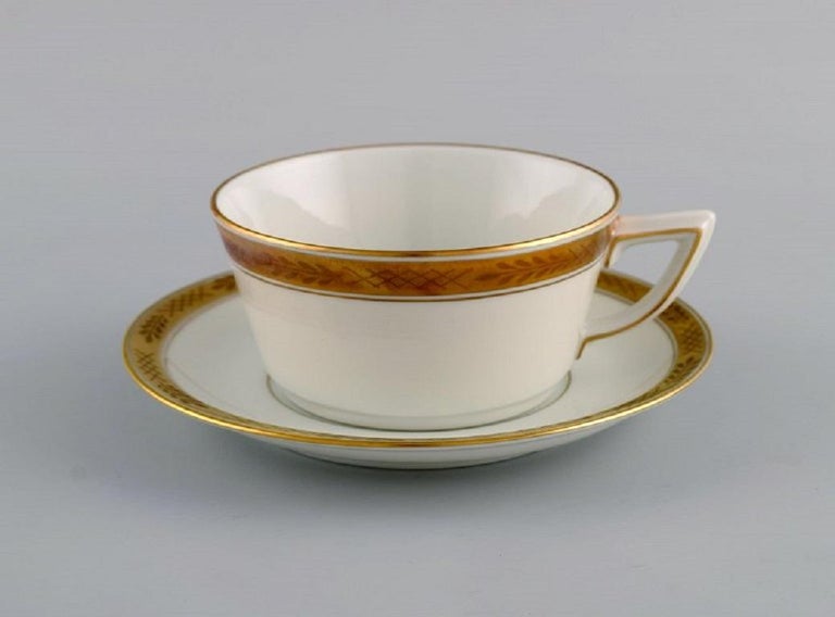 Royal Copenhagen service no. 607. Five teacups with saucers. 
Gold border with foliage. 1960s. Model number 607/9536.
The cup measures: 10 x 5 cm.
Saucer diameter: 15 cm.
In excellent condition.
Stamped.
1st factory quality.