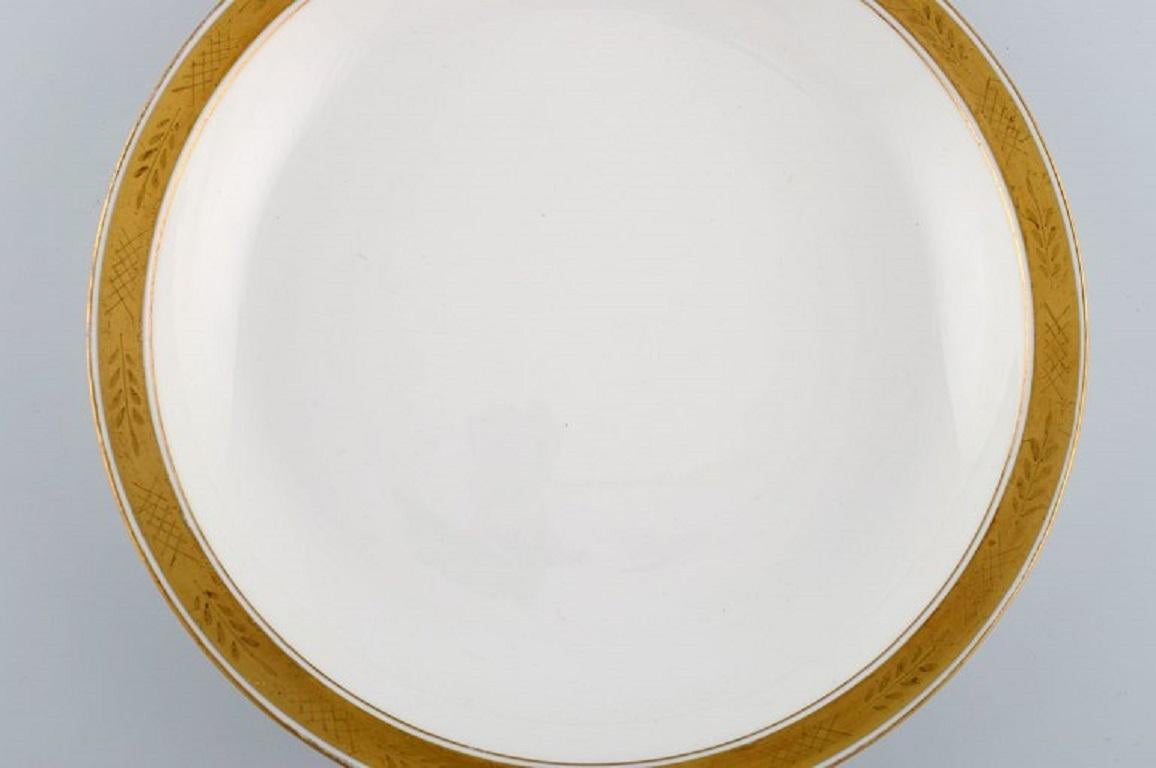 Royal Copenhagen service no. 607. Round porcelain serving dish. 
Gold border with foliage. Model number 607/9582. Dated 1946.
Measures: 27 x 4.5 cm.
In excellent condition.
Stamped.
1st factory quality.