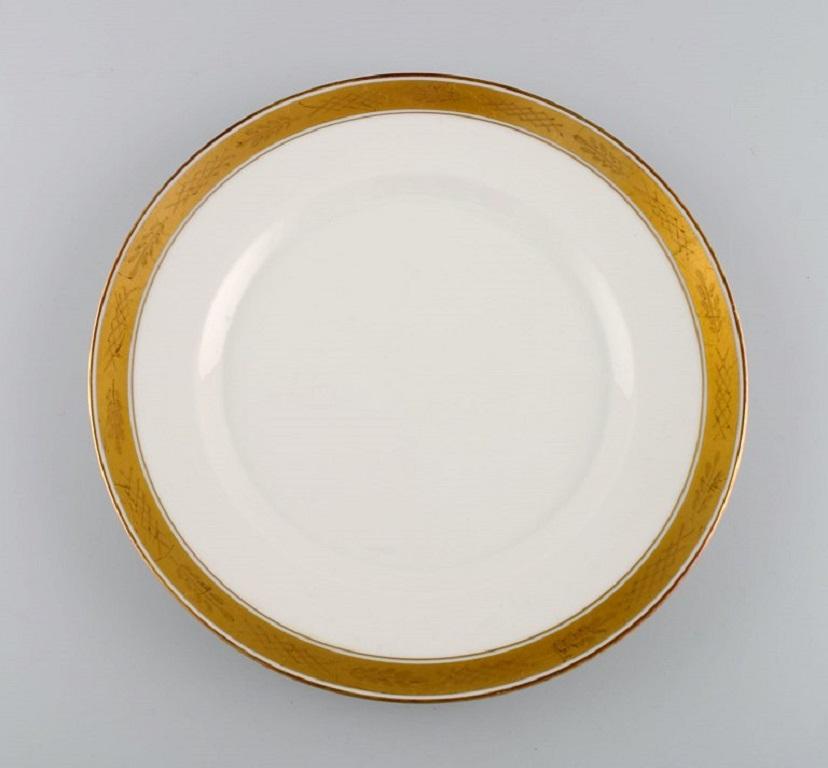 Royal Copenhagen service no. 607. 
Six assiettes à dîner en porcelaine. Bordure dorée avec feuillage. Numéro de modèle 607/9586. 
Daté de 1944.
Diamètre : 25 cm.
En parfait état.
Estampillé.
1ère qualité d'usine.