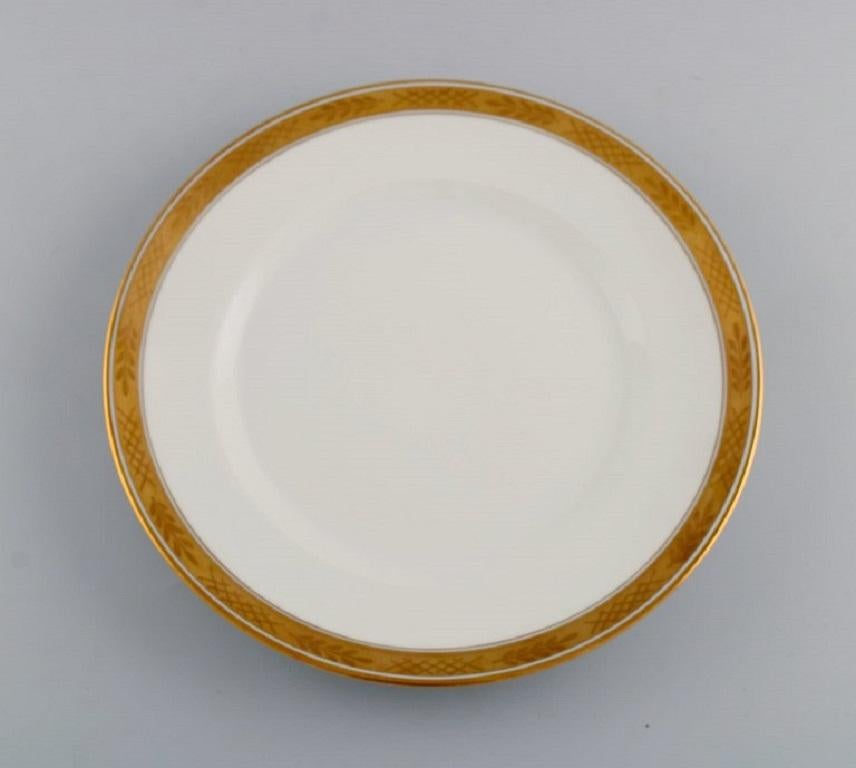 Royal Copenhagen service no. 607. Twelve porcelain dinner plates. 
Gold border with foliage. Model number 607/9586. 
Dated 1960's.
Measure: Diameter: 25 cm.
In excellent condition.
Stamped.
1st factory quality.
