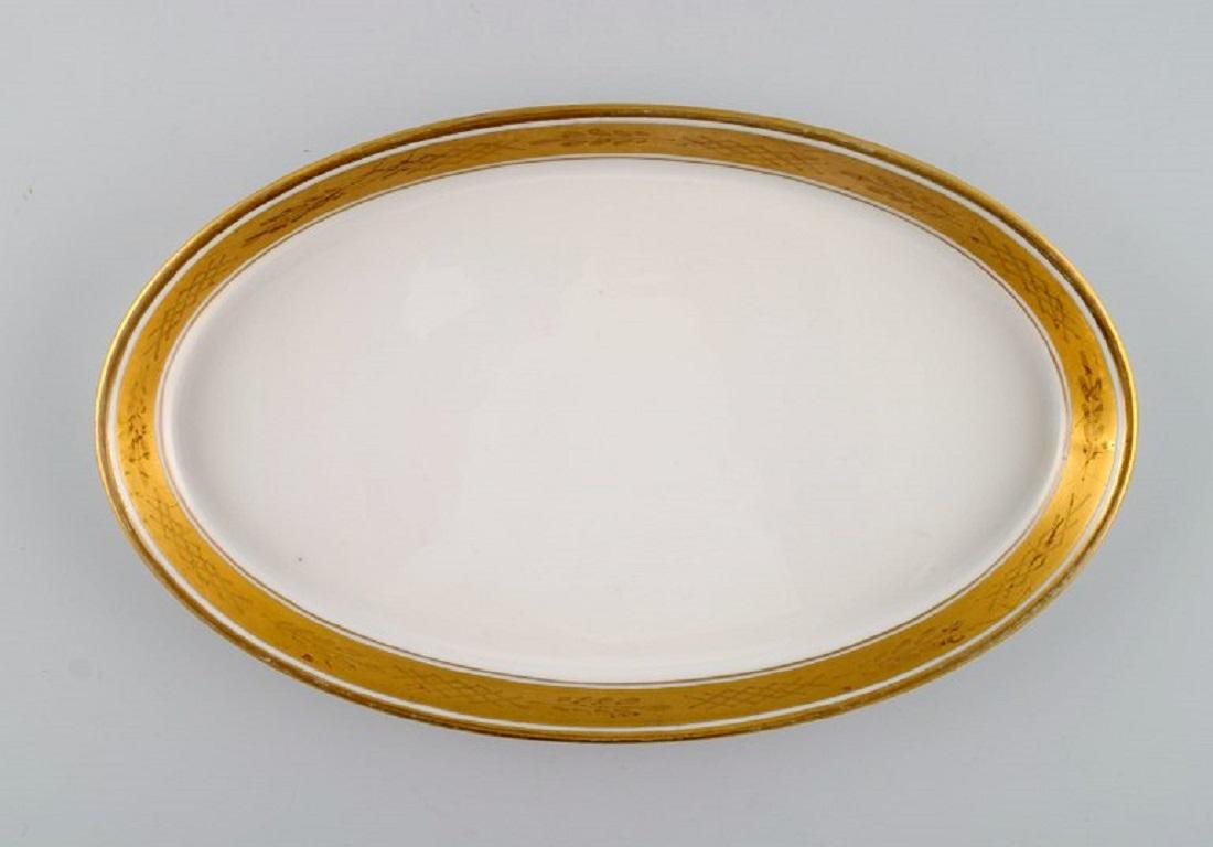 Royal Copenhagen service no. 607. Two oval porcelain dishes. 
Gold border with foliage. Model number 607/9499. 
Dated 1944.
Measures: 22 x 13.5 x 2.2 cm.
In excellent condition.
Stamped.
1st Factory quality.