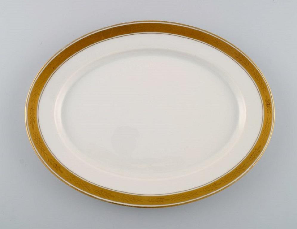 Royal Copenhagen service no. 607. Two oval porcelain dishes. 
Gold border with foliage. 1940s.
Largest measures: 28 x 21 cm.
In excellent condition.
Stamped.
1st factory quality.