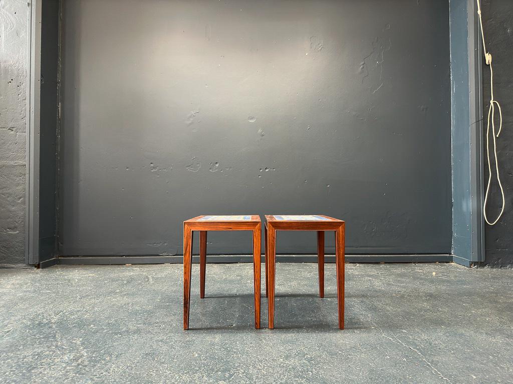 This pair of stunning side tables were created by Danish designer Severin Hansen in 1960s. Made from hardwood these tables are inlaid with tiles from iconic porcelain manufacturer Royal Copenhagen's 'Tenera' series by Nils Thorsson, the rich royal