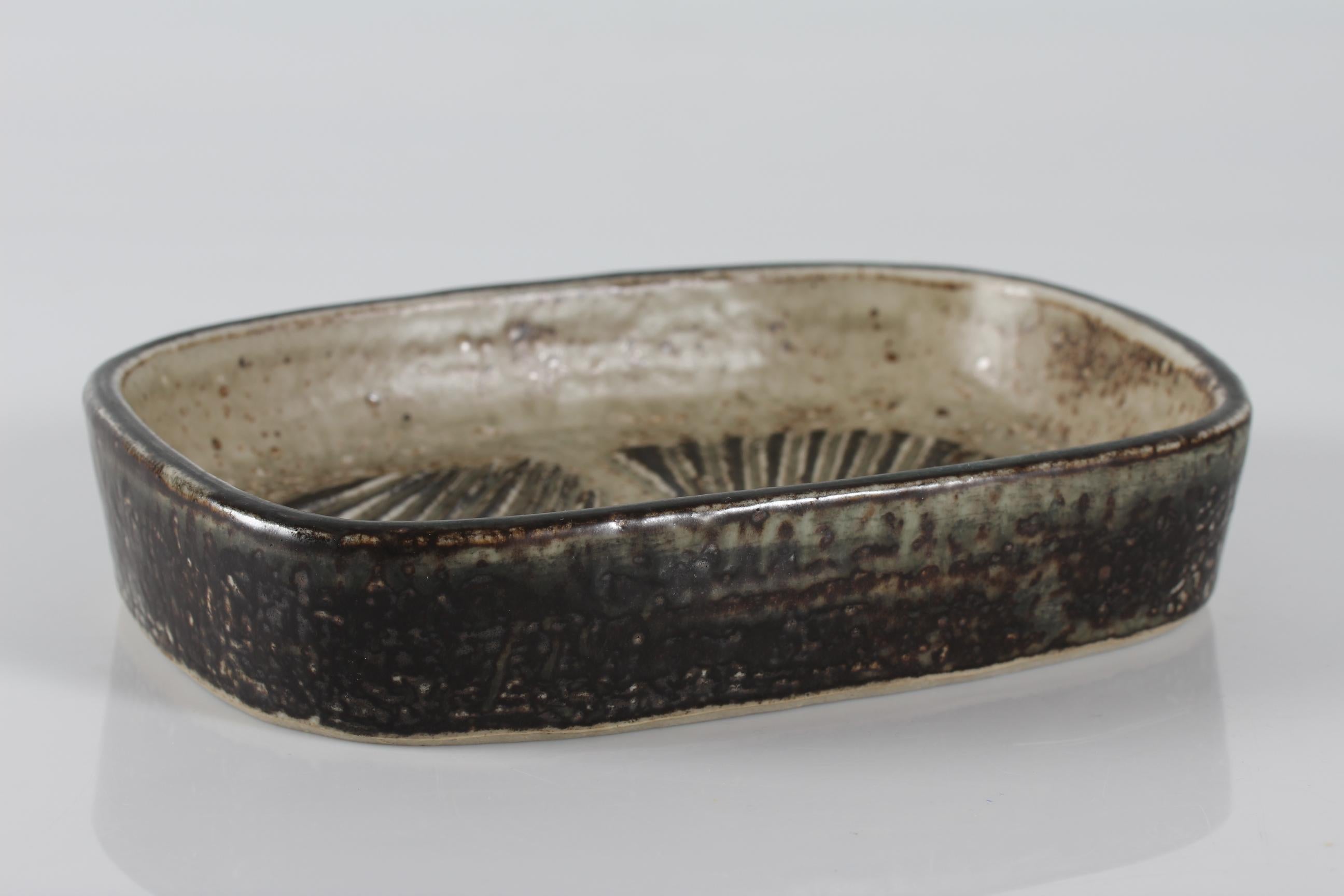 Rectangular stoneware dish model no. 22361 designed by Danish ceramist and artist Eva Stæhr-Nielsen (1911-1976) and manufactured by Royal Copenhagen

The dish is decorated with sung glaze and has the signature E. St. N. for Eva Stæhr Nielsen
Sung