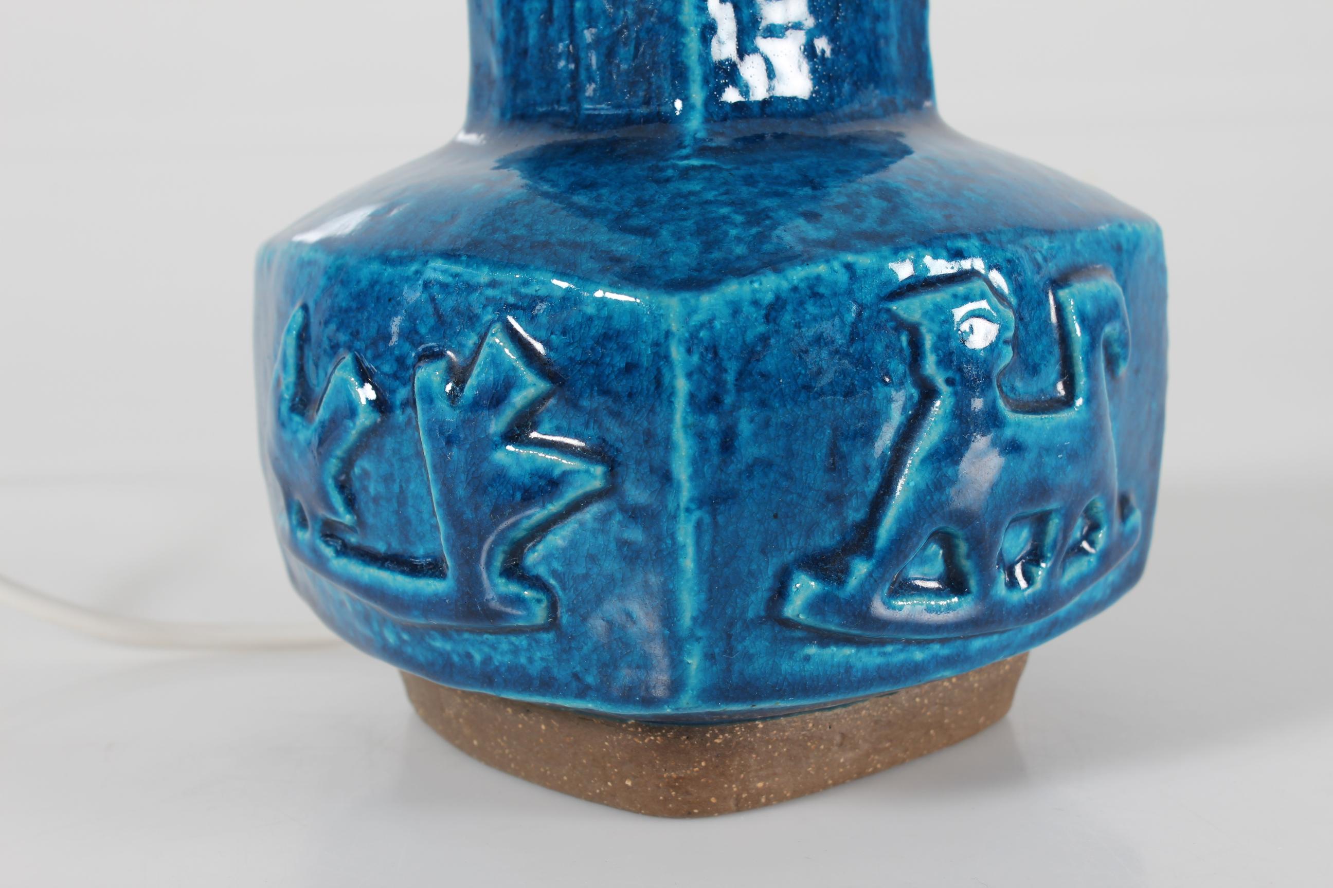 Pied de lampe carré en grès n° 21702 conçu par le céramiste danois Jørgen Mogensen et fabriqué par Royal Copenhagen au Danemark.

La base de la lampe est recouverte d'une glaçure brillante bleu turquoise et présente des motifs d'oiseaux sur les