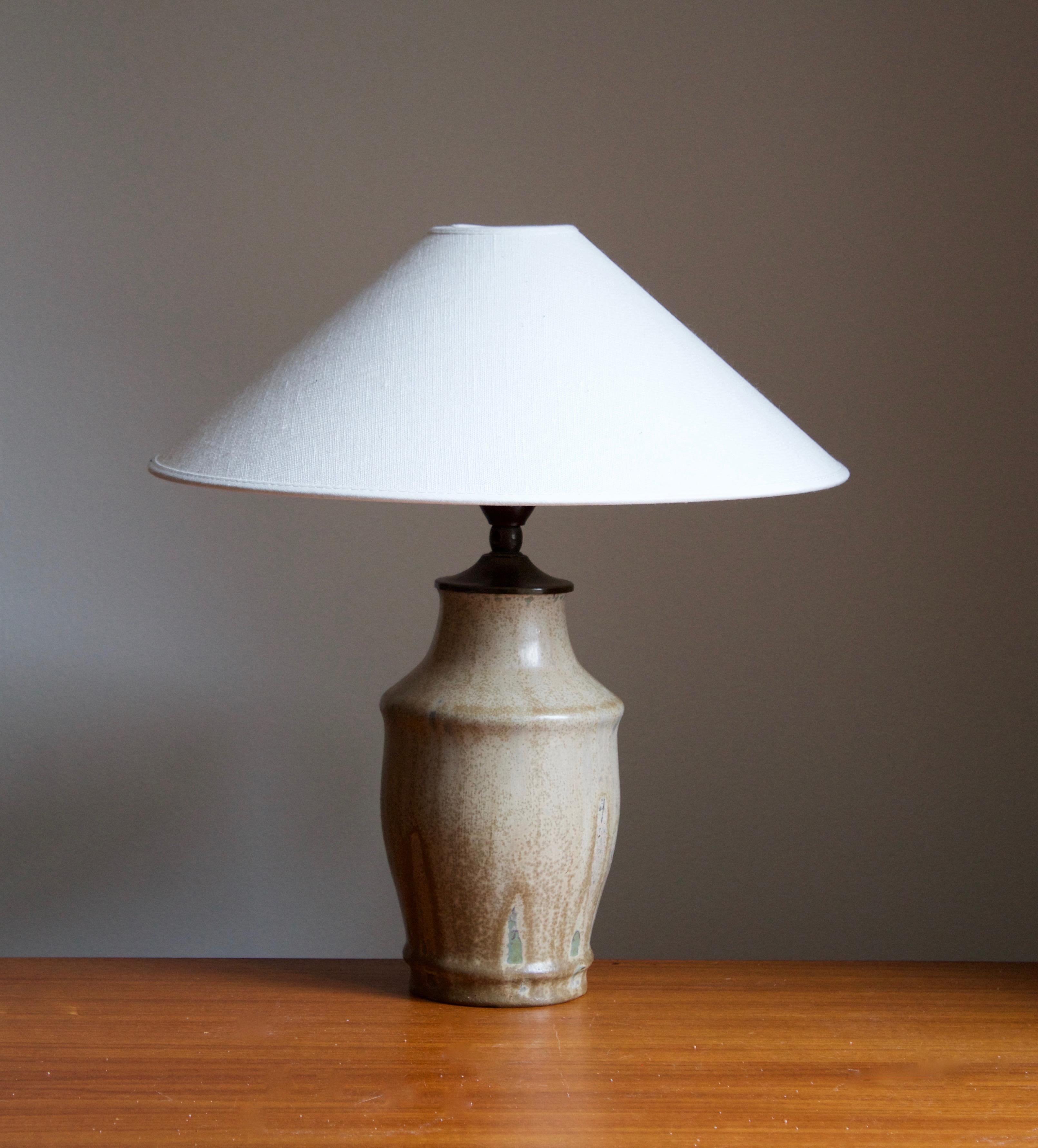 A table lamp designed and produced Royal Copenhagen, Denmark, 1940s. Marked. 

Sold without lampshade. Stated dimensions exclude lampshade, height includes socket.

Glaze features brown-beige colors.