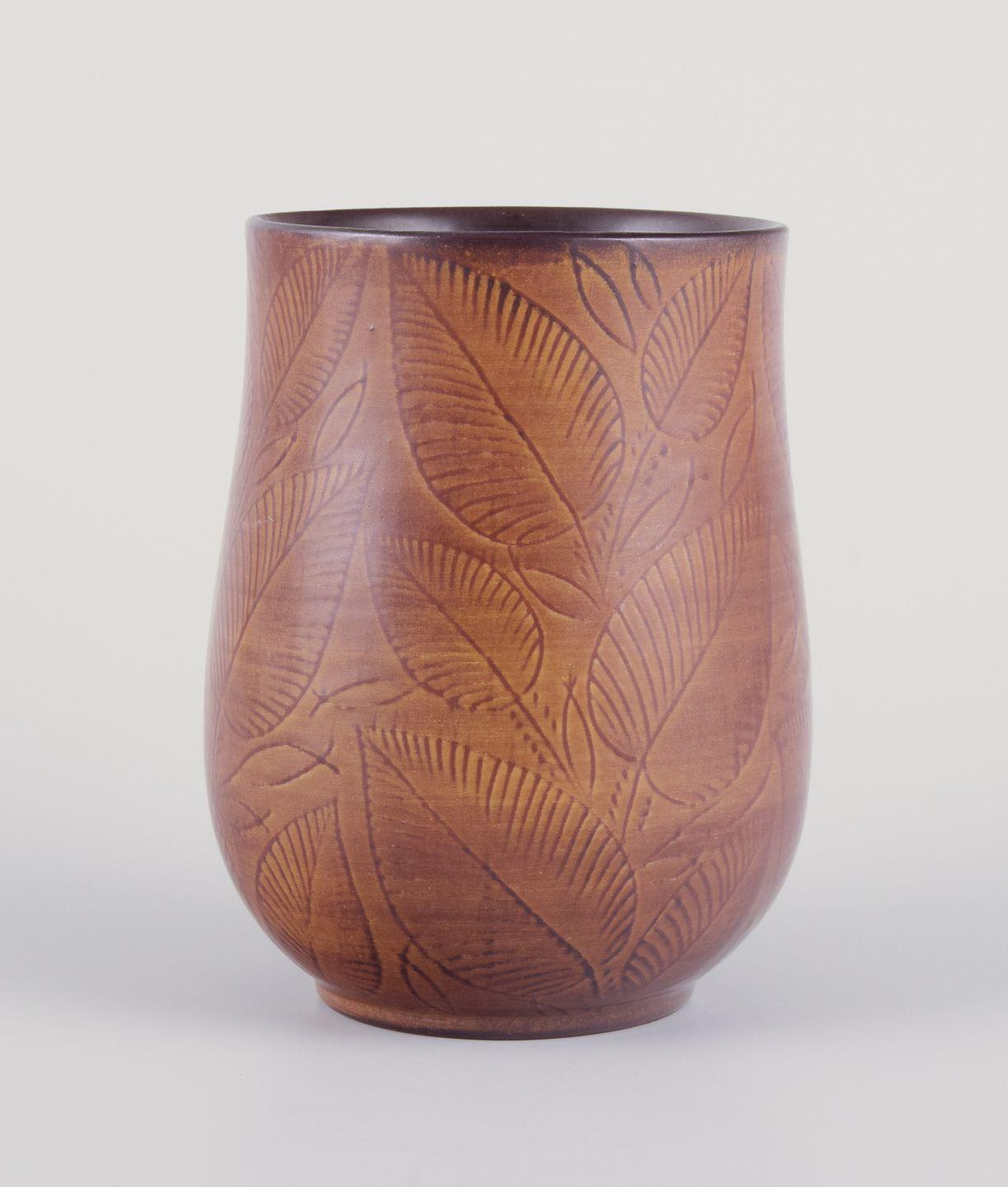 Pre-owned goods are exempt from import duties for U.S. customers. 
Therefore, no import tariffs will be applicable to your purchase.

Royal Copenhagen, vase in burnt red clay.
Decorated with foliage.
Glaze in brown tones.
Dating: