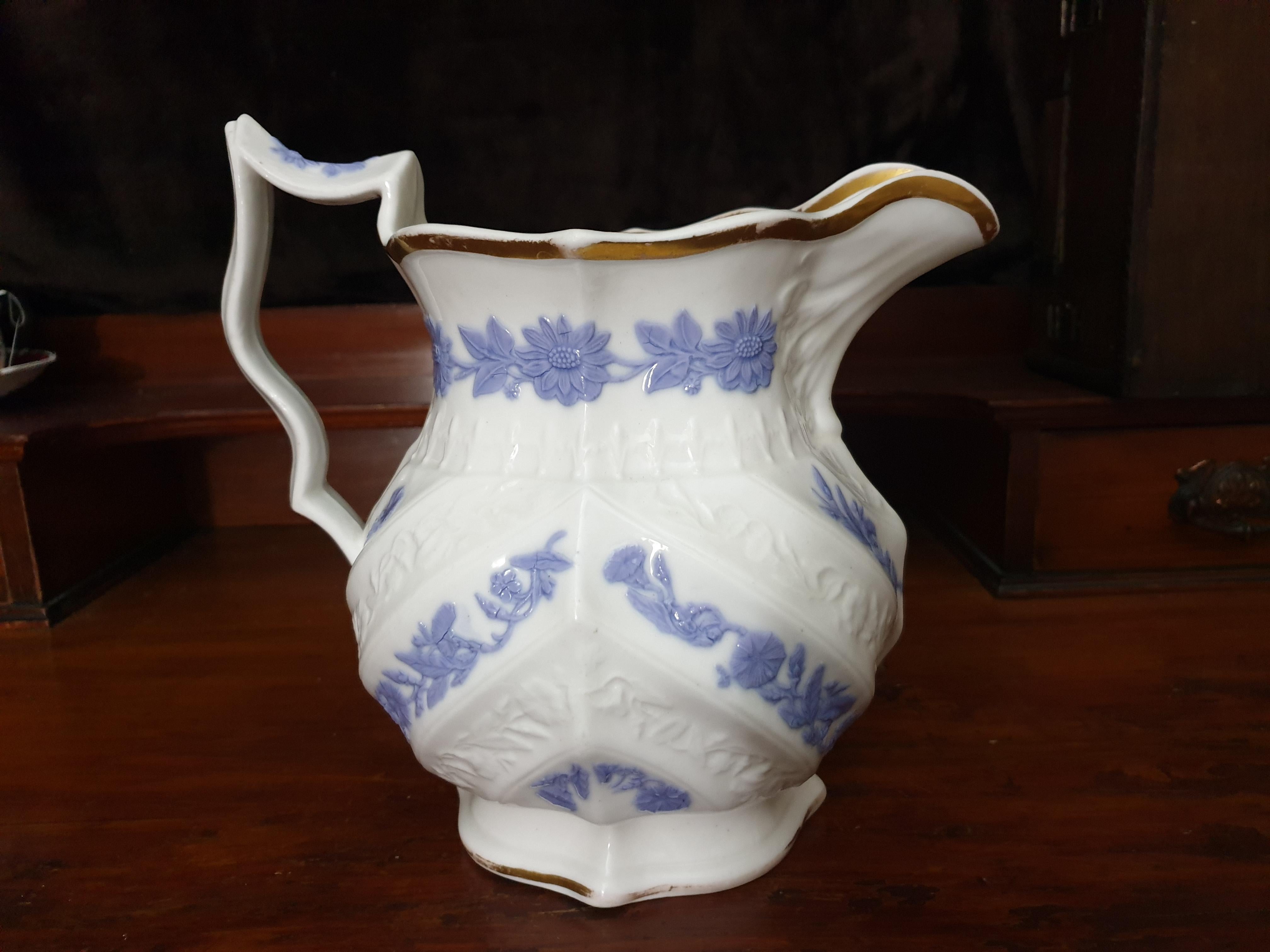 A large Royal Copenhagen water jug, glazed finished with violet embossed sun flowers and flowers finished in 24-karat gold gilt with white embossed flowers. Minor loss of gilding.