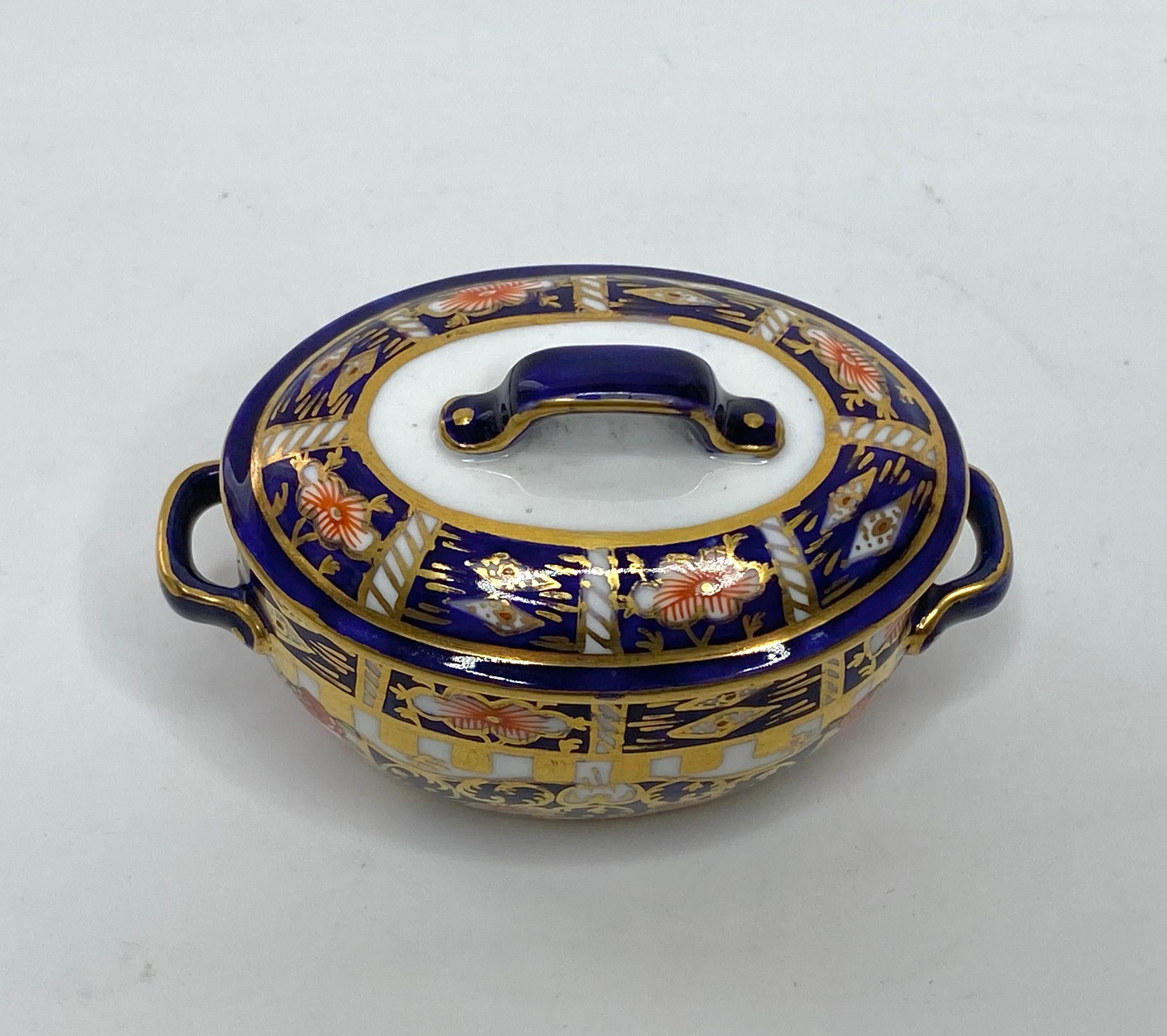Royal Crown Derby miniature fish kettle and cover, dated 1922. The twin handled oval base finely potted, and decorated in a rich Imari design, hand painted in red, green and gilt, on an underglaze blue ground.
The cover similarly decorated.

Printed