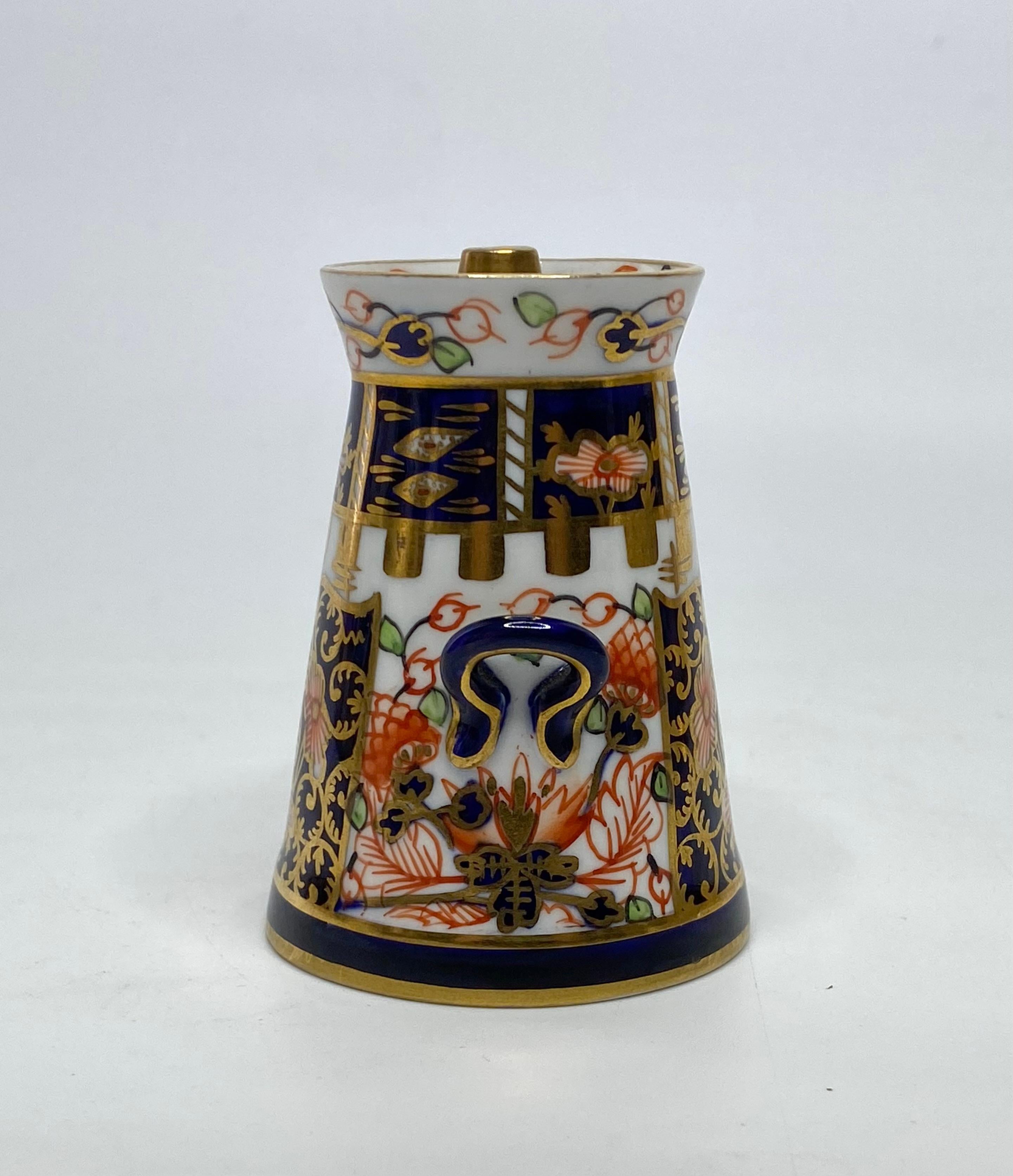 Royal Crown Derby miniature milk churn and cover, dated 1921. The conical churn, finely potted, with twin loop handles, and decorated in a rich Imari design, hand painted in red, green and gilt, on an underglaze blue ground.
The cover similarly