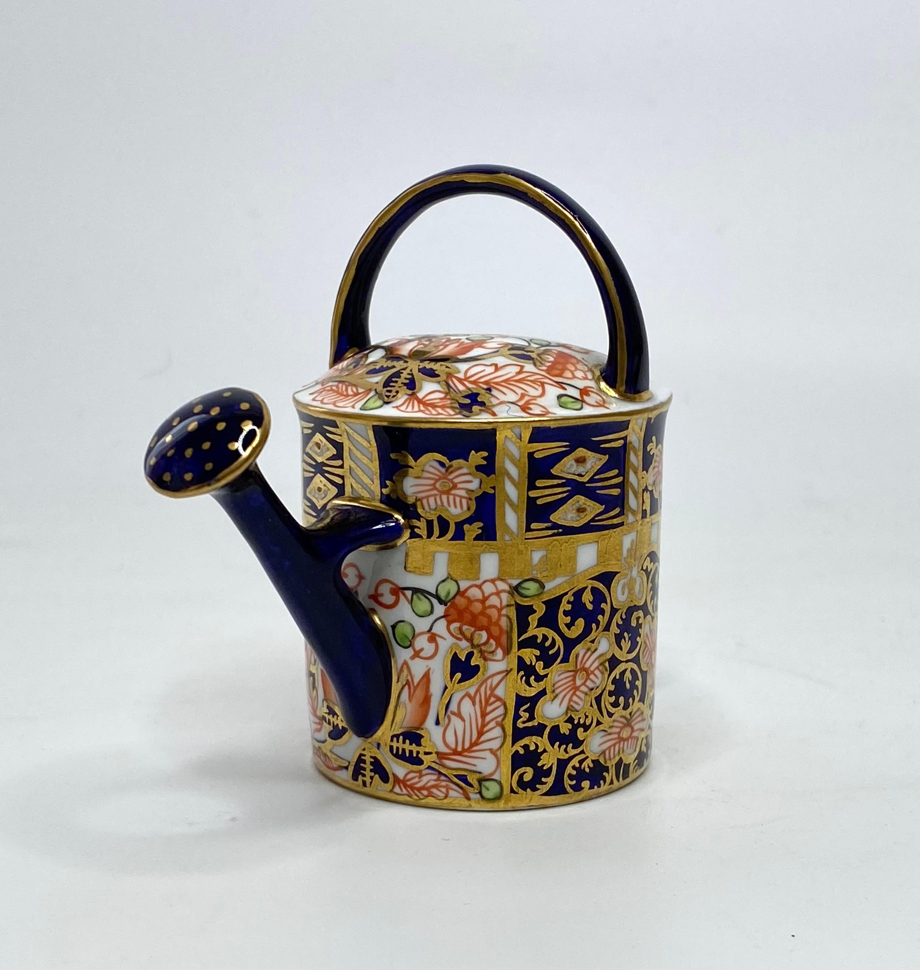 Royal Crown Derby miniature watering can, dated 1922. The traditionally shaped watering can, finely potted, and decorated in a rich Imari design, hand painted in red, green and gilt, on an underglaze blue ground.
Printed factory marks, and date code
