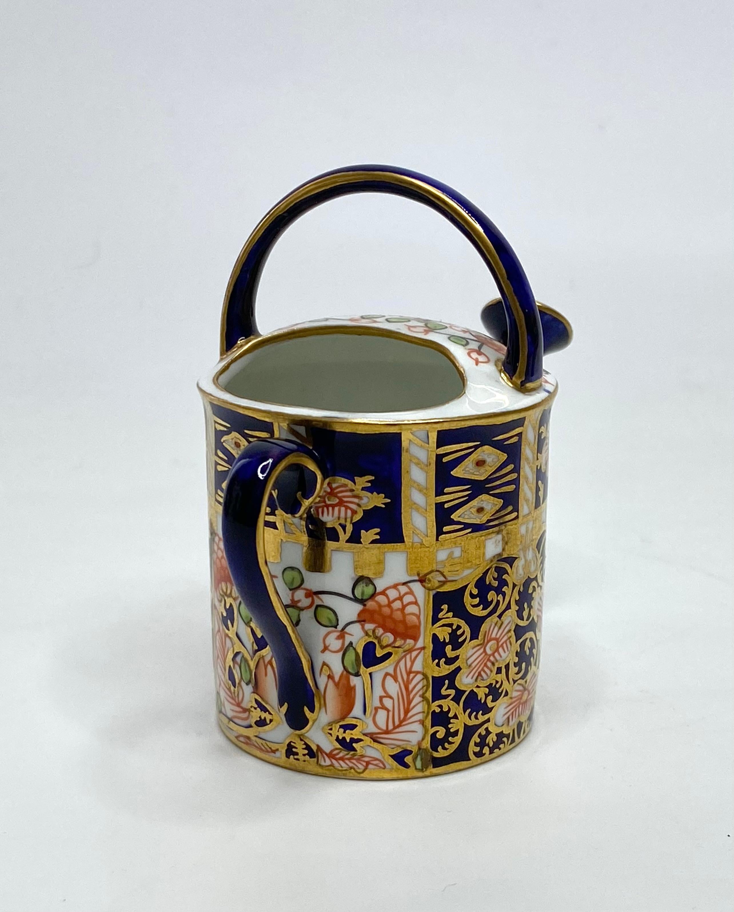Fired Royal Crown Derby miniature watering can, d. 1922.