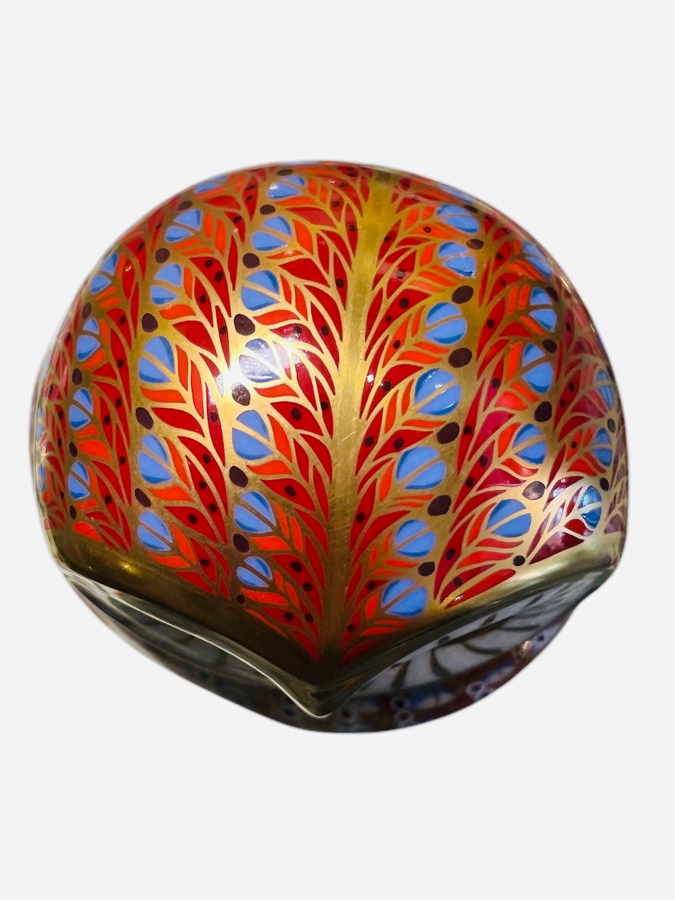 This a Royal Crown Derby porcelain Imari style owl figurine paperweight. It is hand painted in vivid colors of red, different shades of blues and white feathers highlighted by gold. It has very expressive eyes. Below the base, it is the Royal Crown