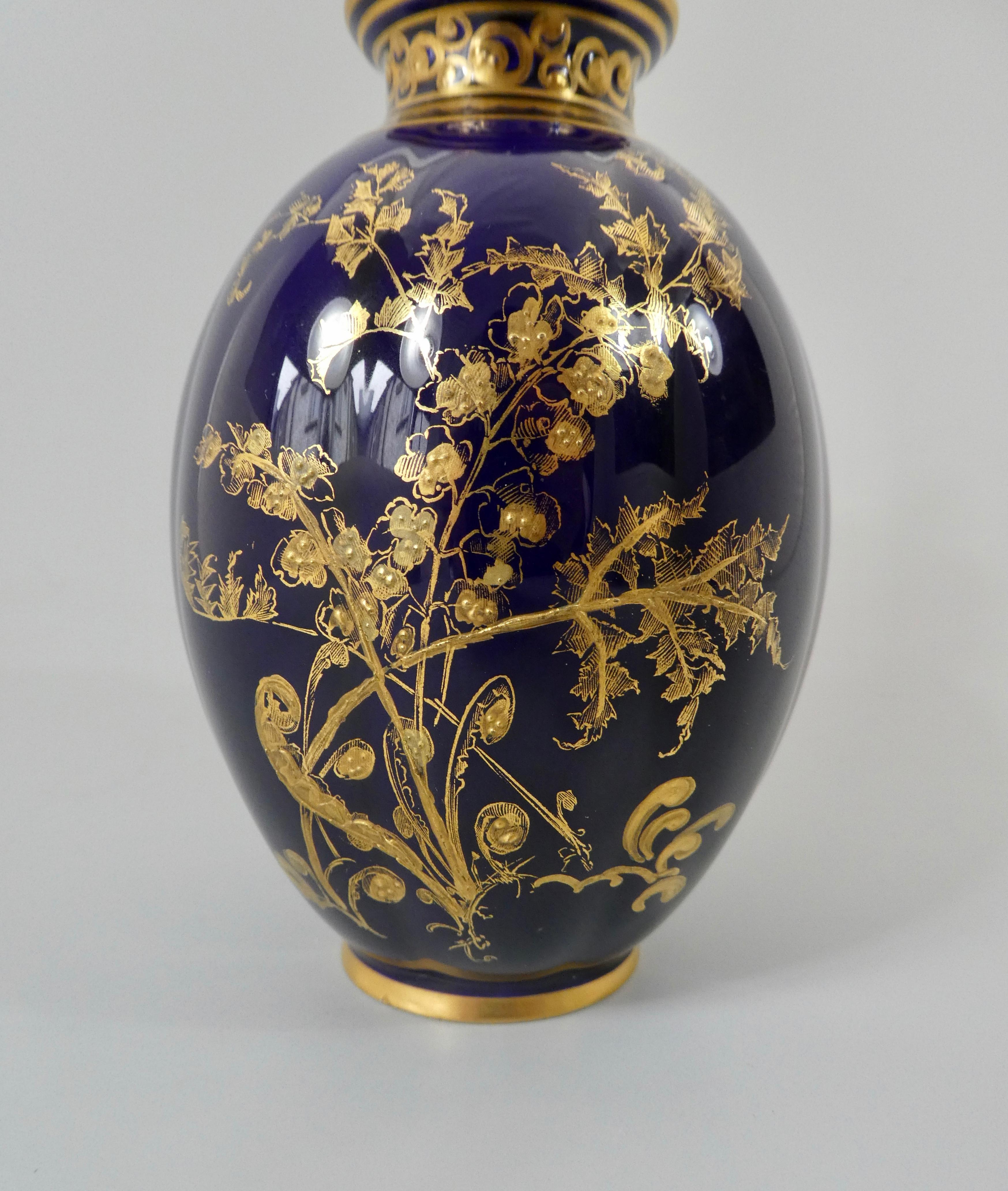 Royal Crown Derby Porcelain vase and cover, dated 1909. The melon shaped vase, finely gilded with flowering plants, on a cobalt blue ground. The cover moulded and gilded scrolling vine, beneath a gilt acorn finial.
Printed marks, and date code for