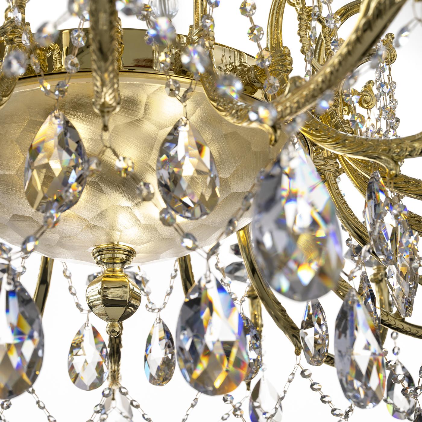 Un grande lampadario a 18 bracci curvi con lampadine e14, completato da 3 luci aggiuntive all'interno di una ciotola centrale in cristallo Florentine smerigliato. Ornato da quattro pendenti di cristallo noti per la loro chiarezza e brillantezza,