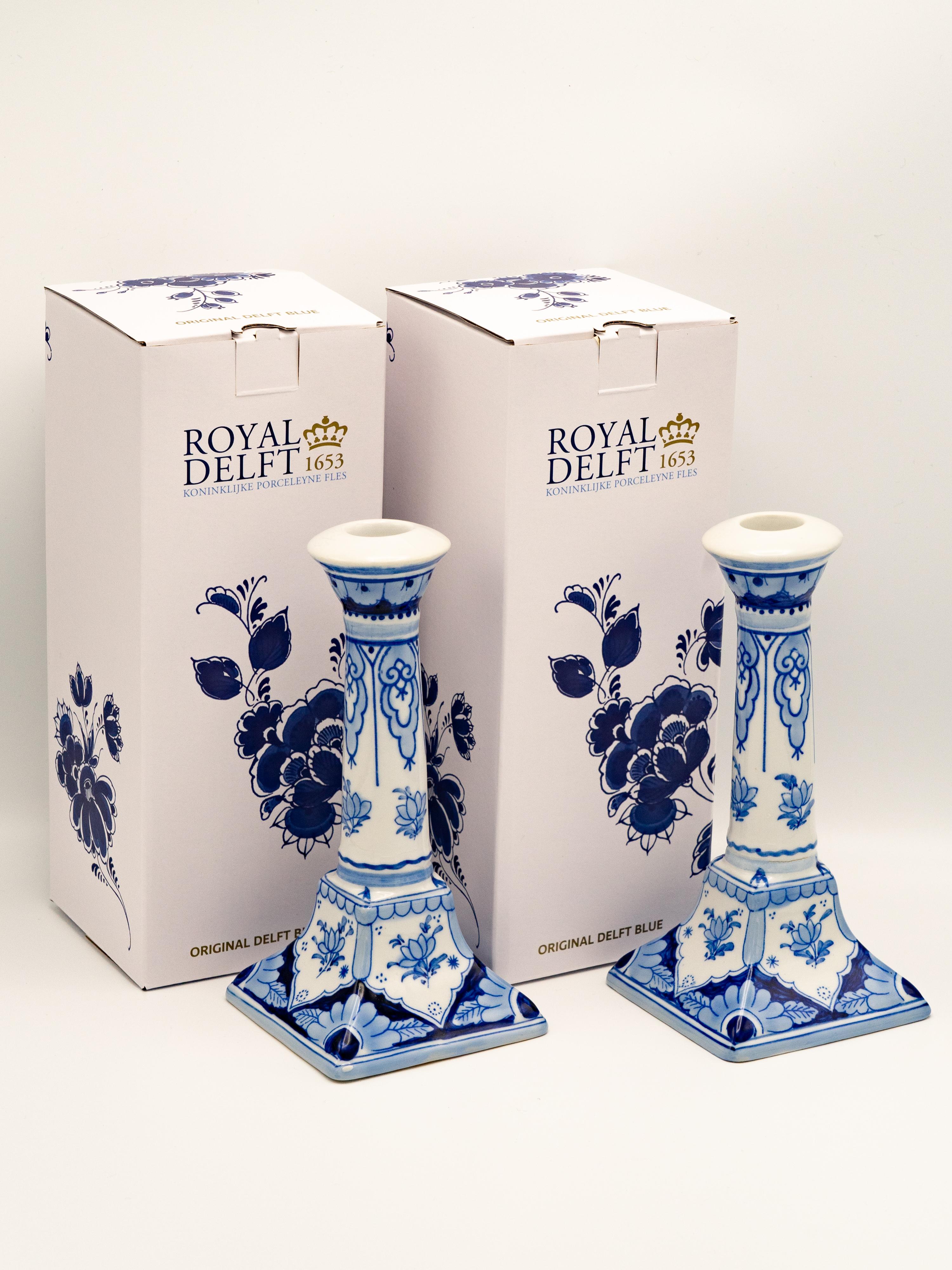 This rare and elegant pair of Royal Delft candlesticks, produced by De Porceleyne Fles in 1988, showcases the mastery of Delft Blue craftsmanship. Each candlestick is meticulously hand-painted by master painter H. van Leeuwen, reflecting the