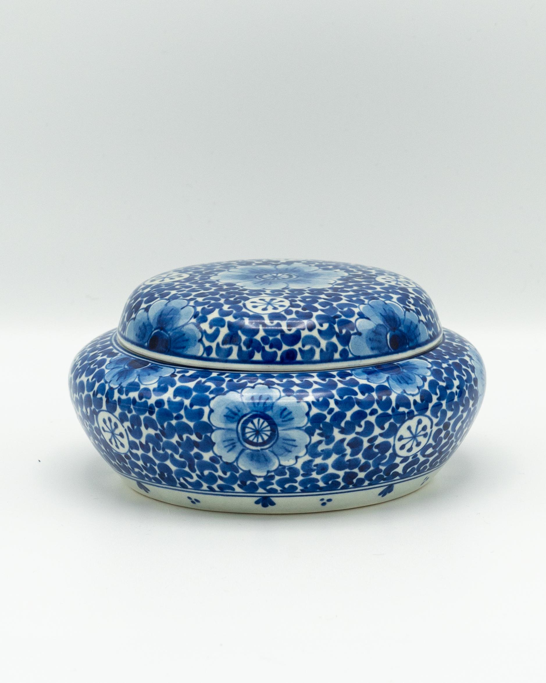 Esta rara y excepcional bombonera azul Royal Delft, producida por De Porceleyne Fles para conmemorar el tricentenario de la fábrica (1653-1953), es una pieza de coleccionista muy buscada. Marcada con la inscripción especial 1653-1953 en la base,