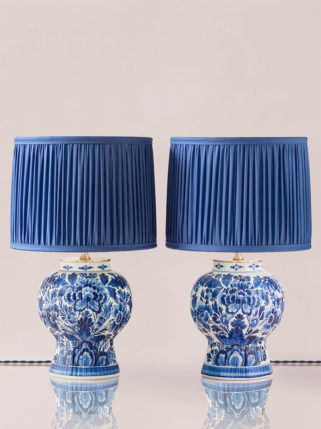 Exquisitely handcrafted by Amitābha Studio in Amsterdam from vintage Royal Delft Blue vases, Azul & Alba are a one-of-a-kind pair of table lamps. The vase bases, meticulously painted by Royal Delft master painters in 1964 and 1978, serve as the base