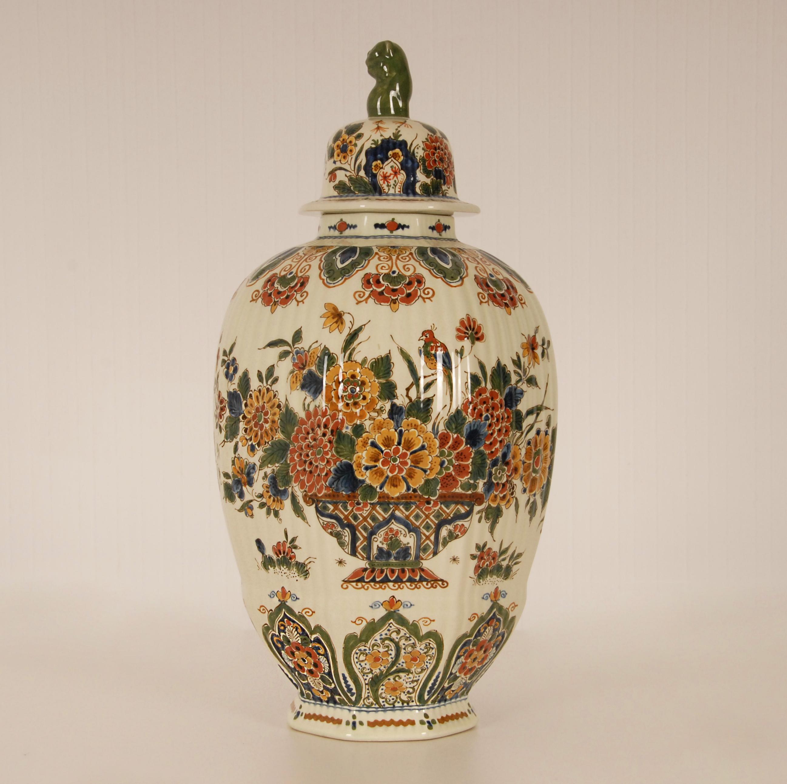Dutch Royal Delft Polychrome Delft vase - Urn.
Tall decorative vase with cover and an octagonal foot.
The vase is hand crafted and hand painted in enchanting colors.
Floral decoration Chinoiserie with birds and flower basket.
Origin The