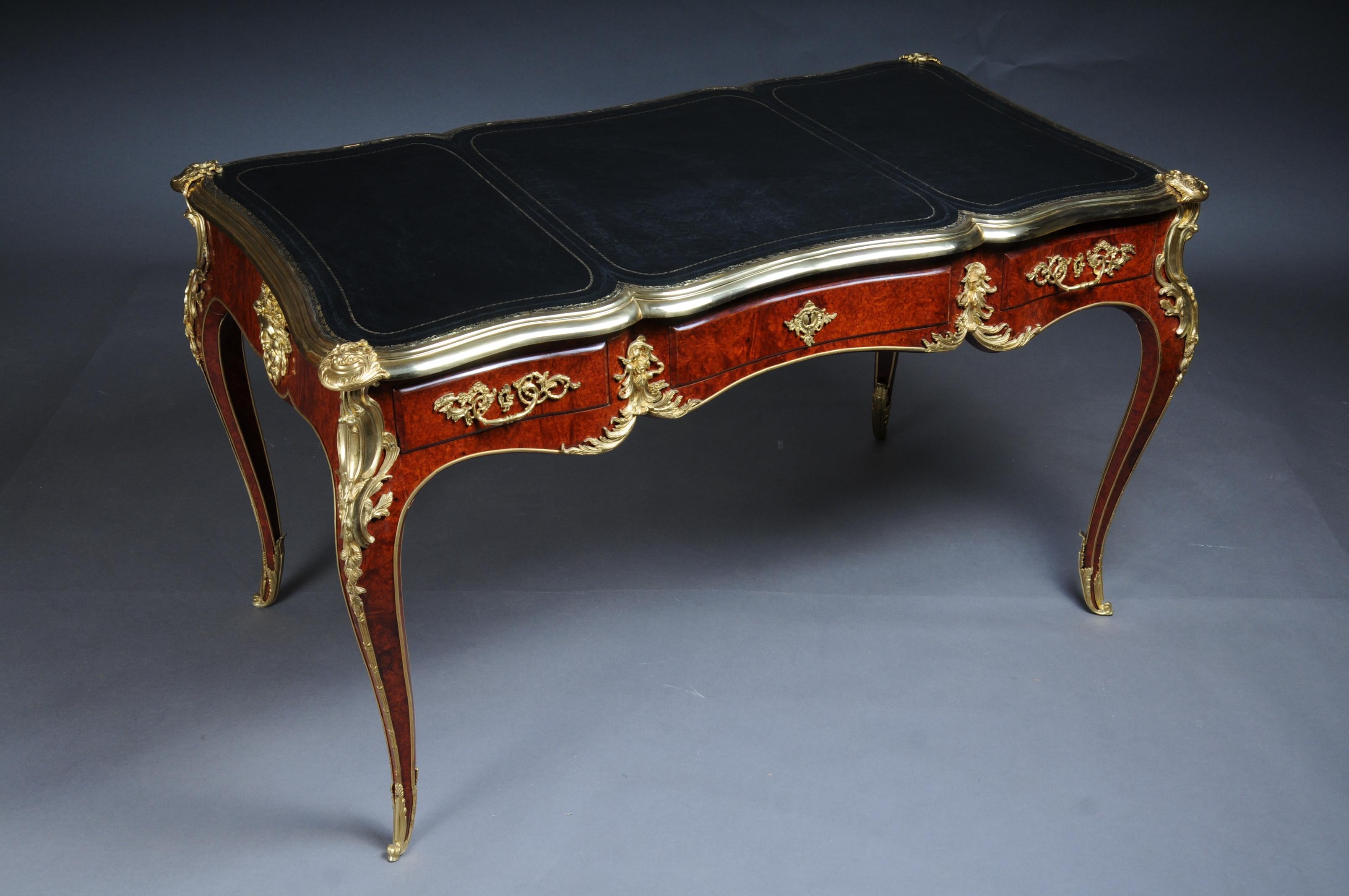 Royal desk / bureau plat in Louis XV style

flamed birch veneer on solid beech wood with rocaille applications. extremely fine, floral, gilded bronze fittings in the form of chutes. Heavily cambered, four-sided curved, three-drawer frame base with a