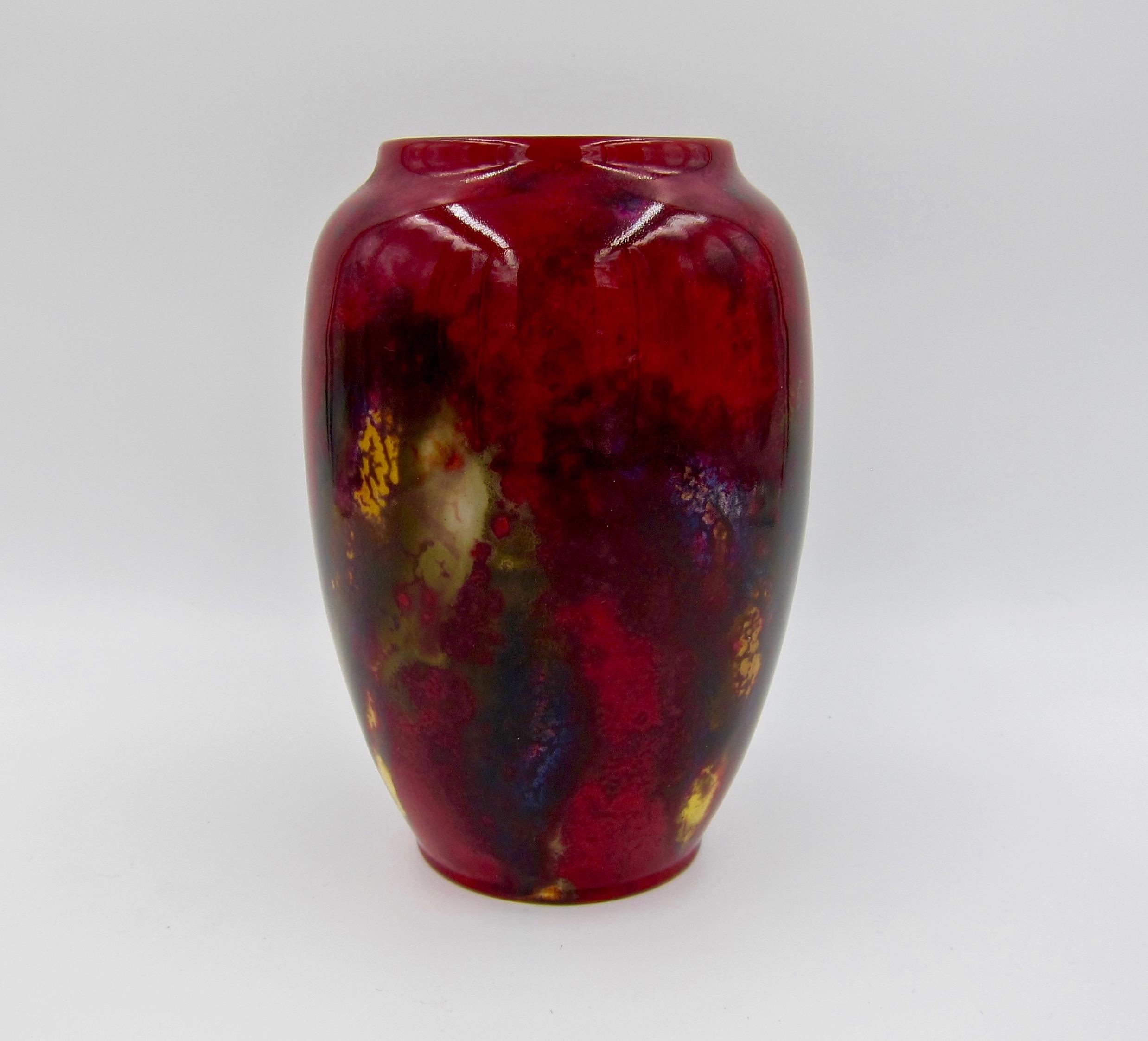An English Art Deco flambé vase by Charles Noke for Royal Doulton, circa 1920s-early 1930s. The art pottery vase has a high-fired glossy flambé glaze of deep, dark red shading to violet, olive, and gold. Doulton's chief designer, Charles Noke