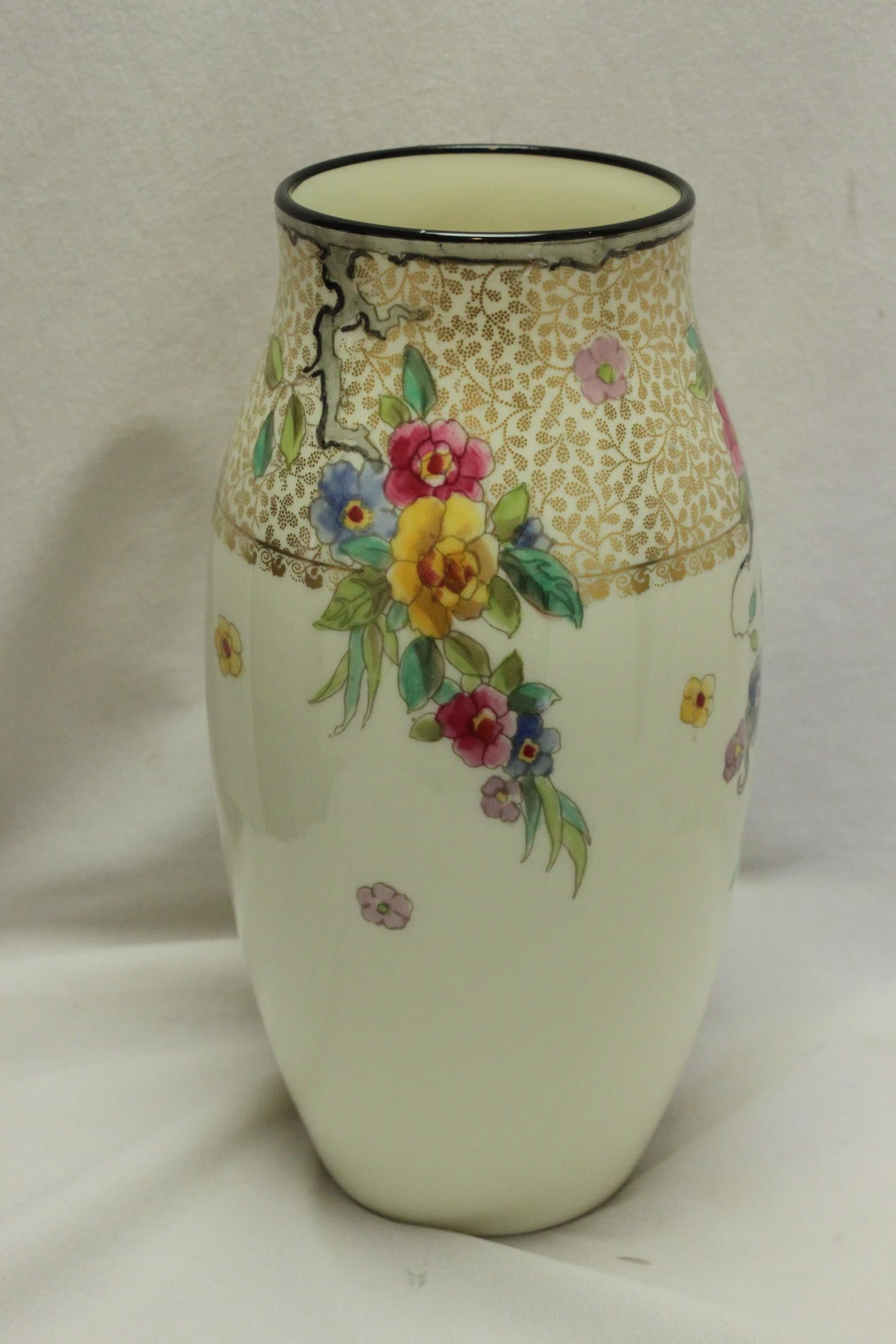 This very pretty Royal Doulton porcelain vase is decorated with a band of gilt filigree to the top, from which three hanging boughs of hand coloured flowers descend down the creamy porcelain body. There are also a number of hand coloured blossoms