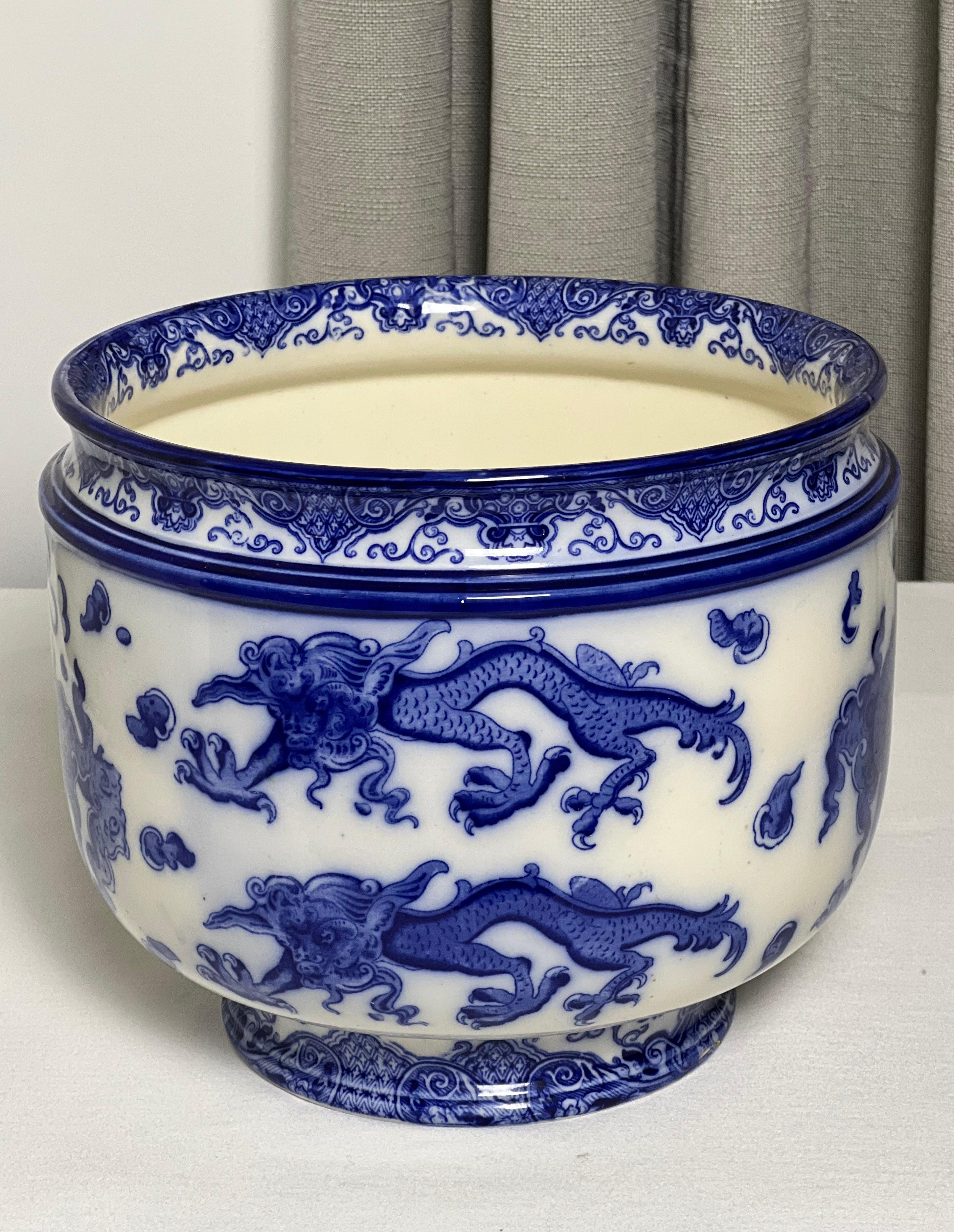 Rare Royal Doulton 'Oyama' pattern porcelain jardinere, circa 1910.

Flow blue jardiniere with a chinoiserie scene of celestial dragons chasing the pearl of wisdom. There is a small crack repair near the base. Royal Doulton backstamp is on the