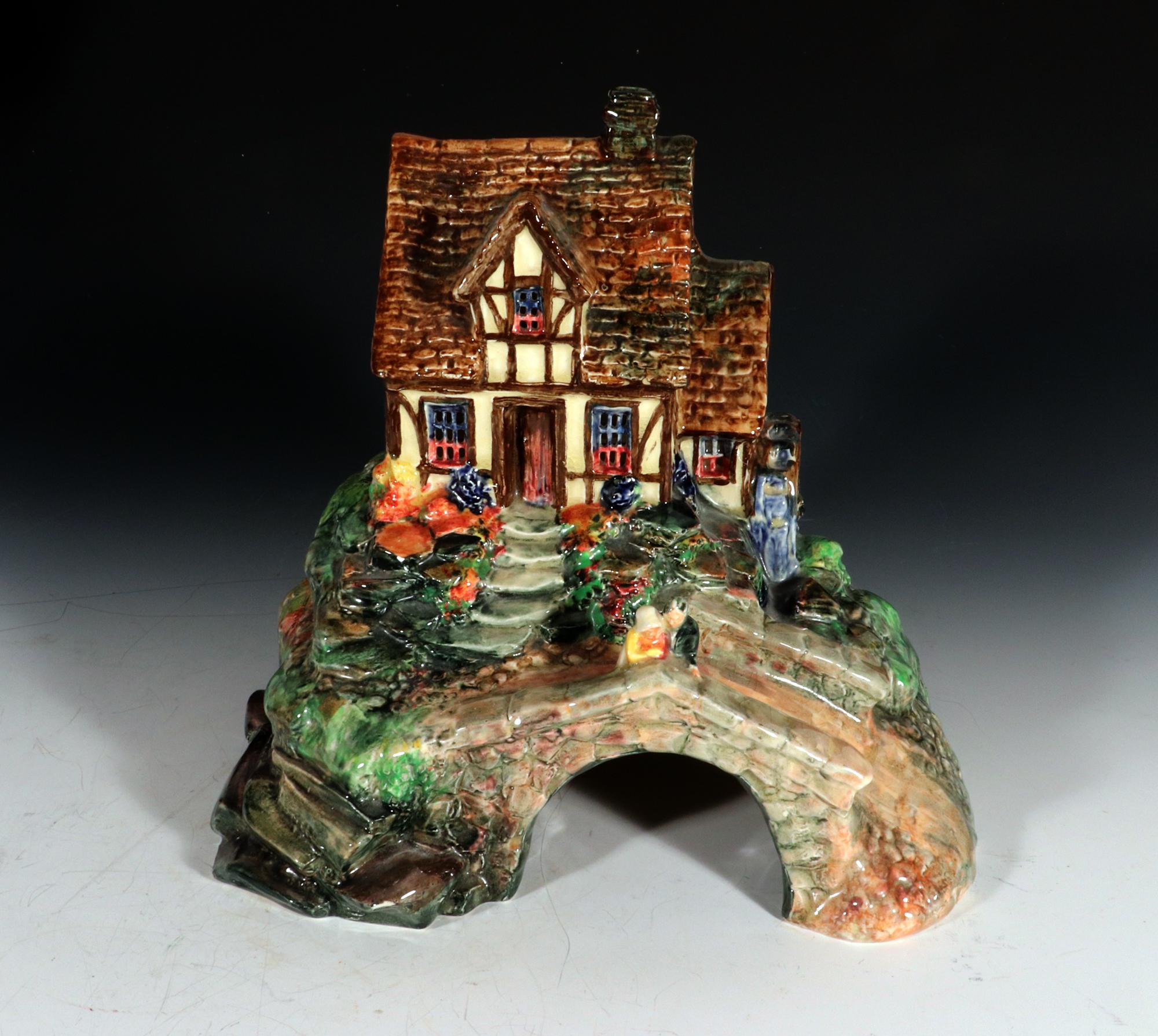 Royal Doulton Pastille Pottery Bastiile Burner Tudor Watermill and Cottage
Burslem,
1920s-30s

The Royal Doulton pottery pastiile burner is modeled as a Tudor watermill and cottage, with a man and woman standing upon the highly detailed cobbled
