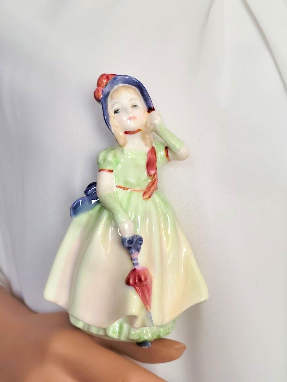 This delightful vintage miniature porcelain figurine Royal Doulton “Babie,” HN 1679, decorated in a light green and blue colorway, was designed by leading Doulton artist Leslie Harradine and was issued from 1935 to 1992.

The size of the figurine is