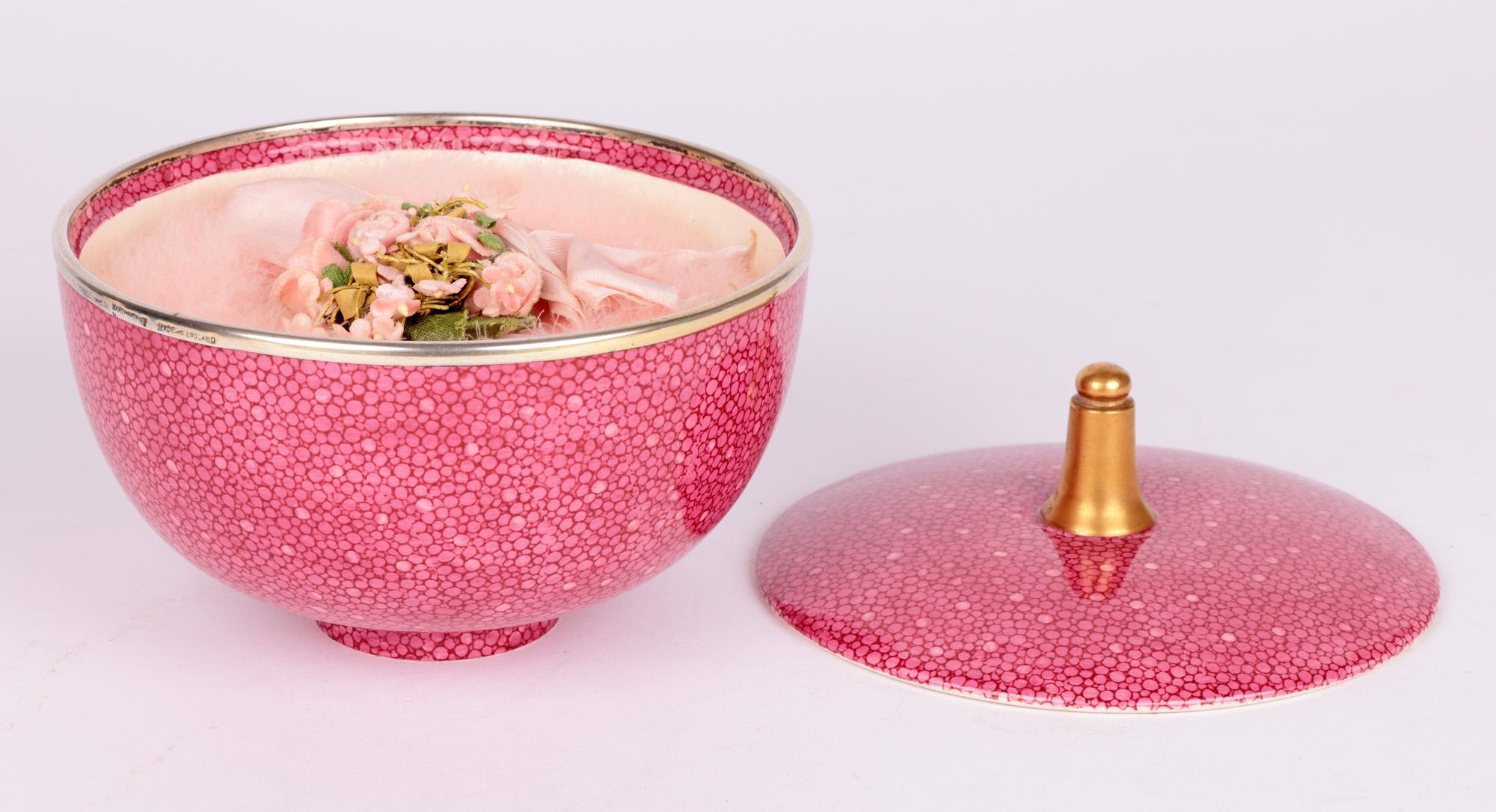 A rare and exceptional Royal Doulton Art Deco silver mounted powder bowl decorated in a pink shagreen design retailed by Hardy & Sons in London and dating from 1924. The round lightly potted bowl stands raised on a narrow round foot with a deep body