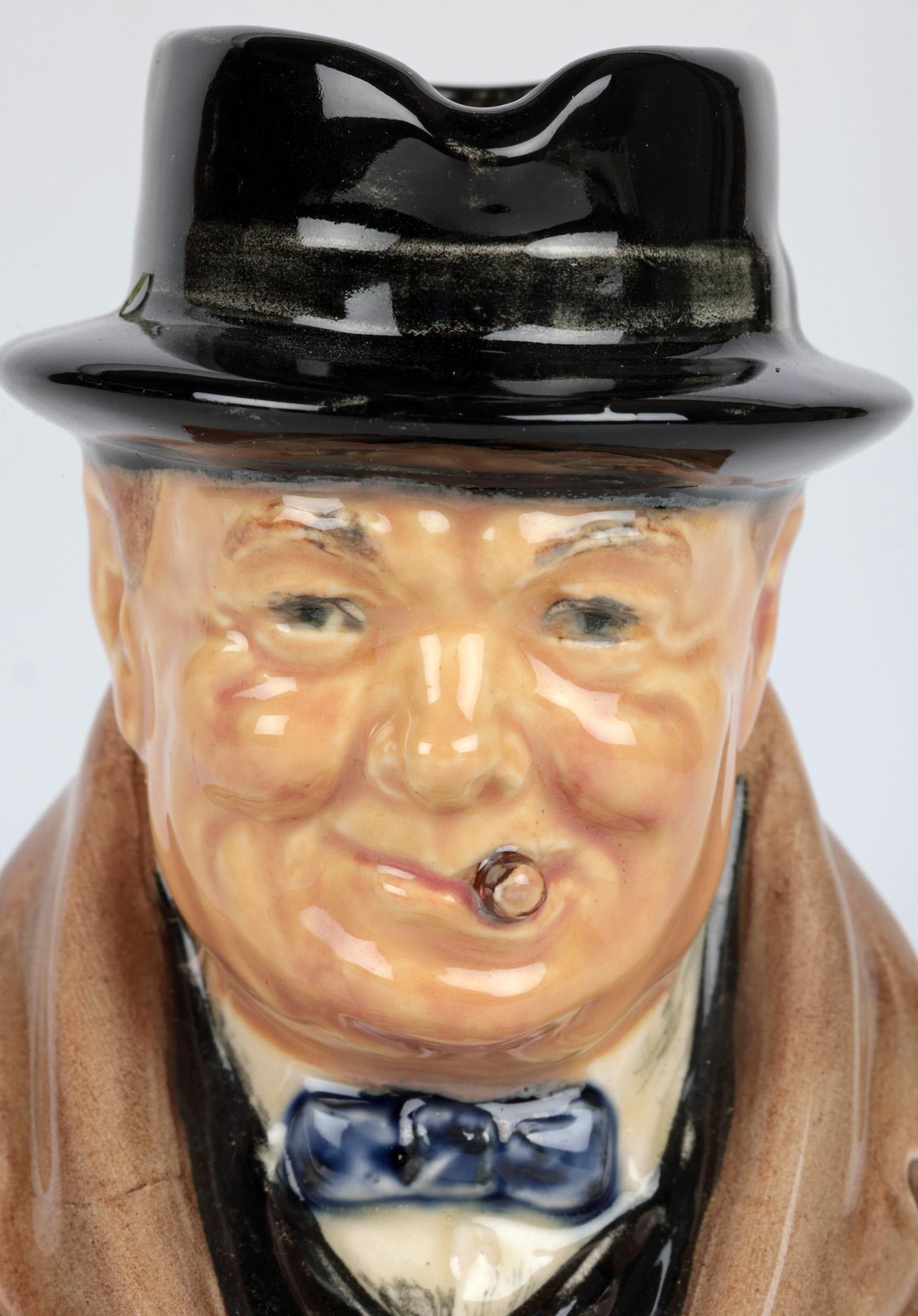 A stylish and scarce Royal Doulton Winston Churchill character jug believed to have been made to commemorate him becoming Prime Minister on 10th May 1940 and dated accordingly. The ceramic jug of small size portrays him sat raised on an oval shaped
