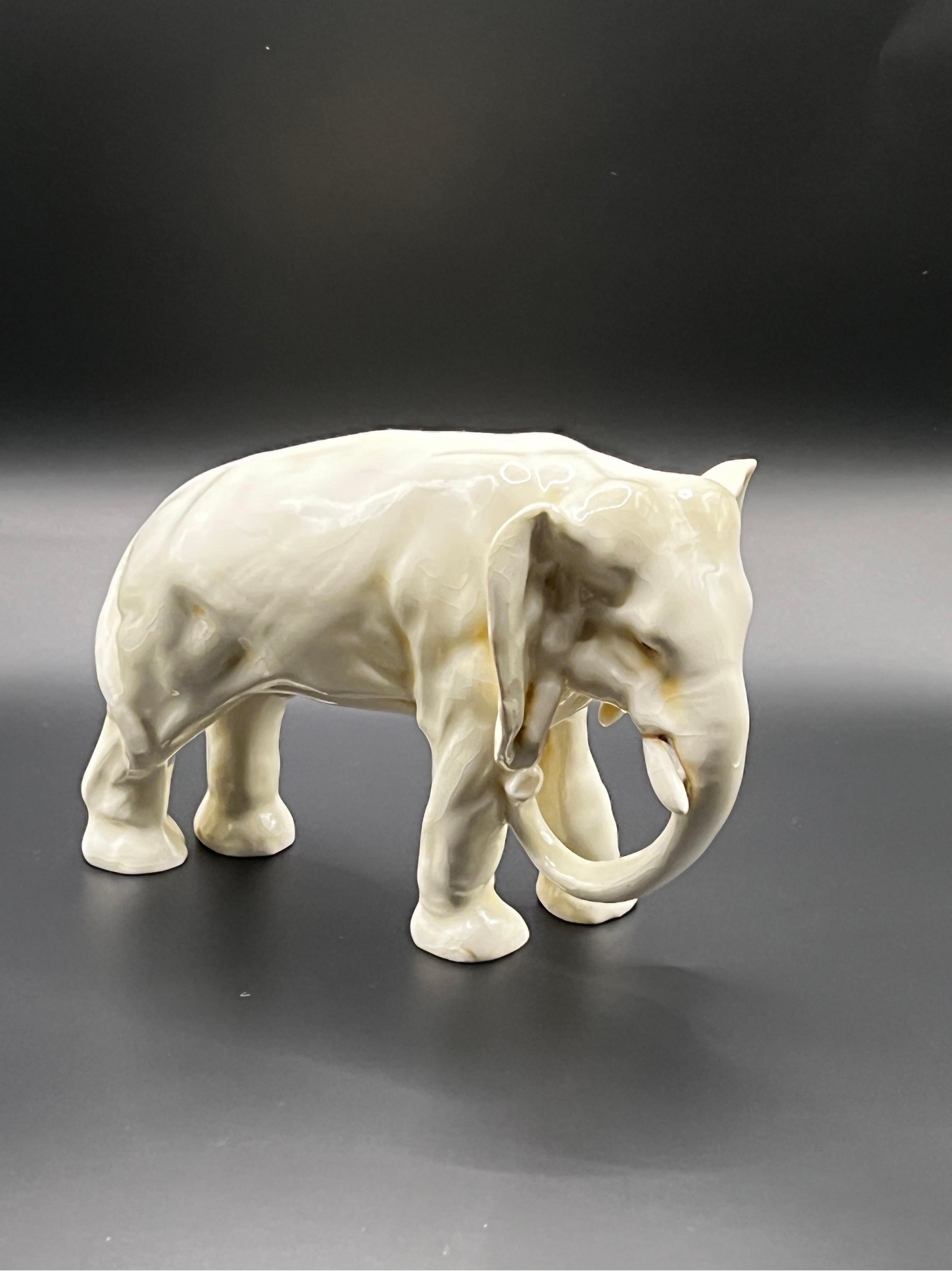 Discover a remarkable and highly coveted treasure: an exquisite biscuit porcelain statue of an elephant, originating from the prestigious Bohemian porcelain factory, Royal Dux, crafted in the late 1930ies. Impeccably preserved, this stunning piece