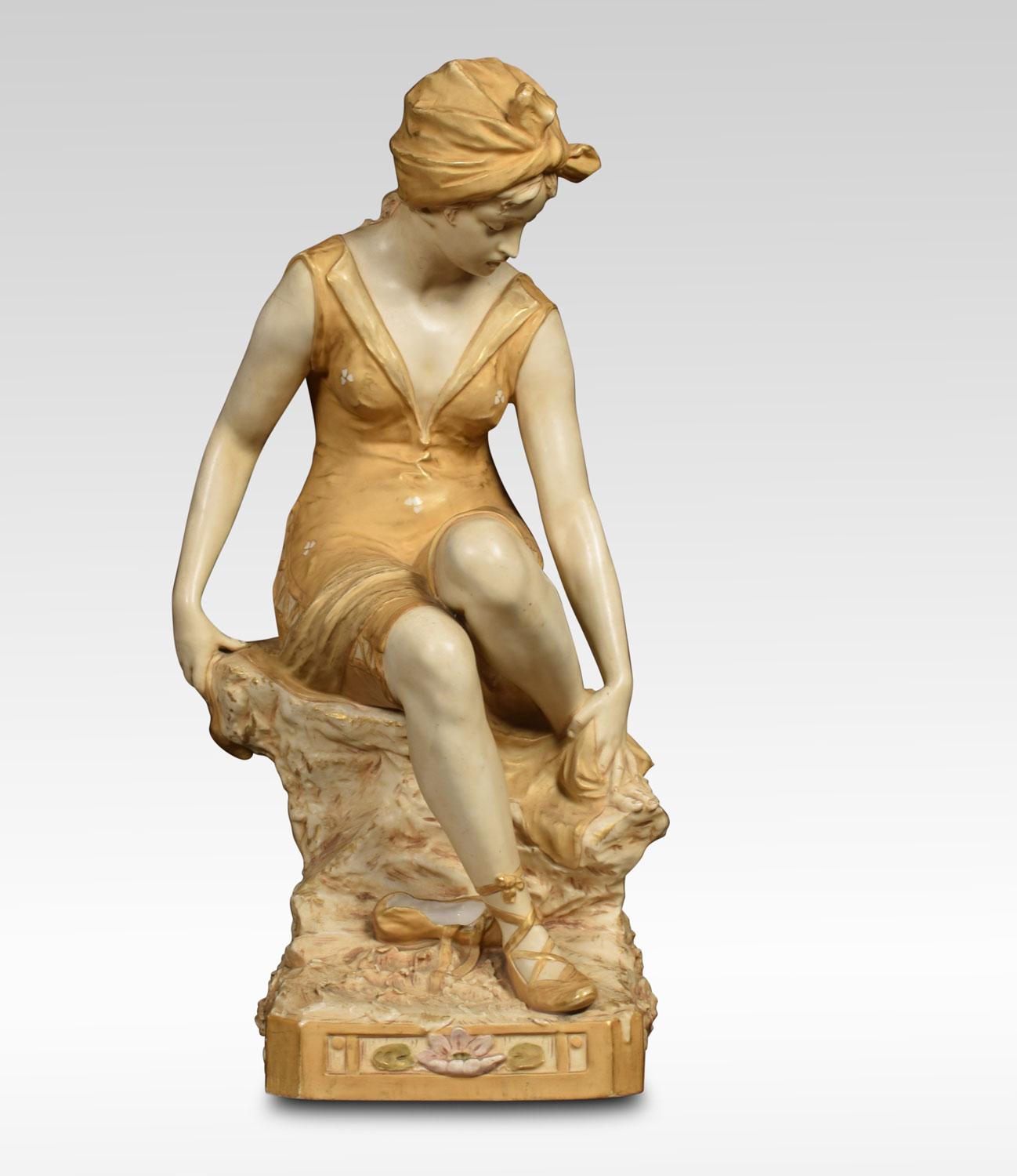 Royal Dux Bohemia porcelain figure of a bather modelled seated on a rock wearing a laced swim suit, head scarf and laced slippers, drying one foot with a towel on canted square base, applied pink triangle.
Dimensions:
Height 19 inches
Width 8