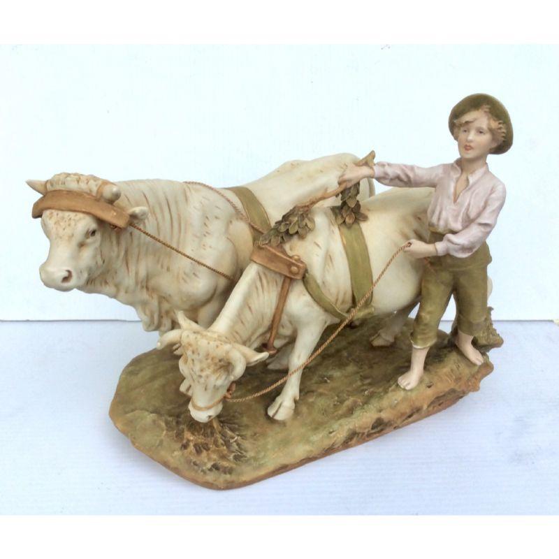 Fabulous Large Antique Royal Dux hand painted porcelain figure of a boy herding cattle. Circa : 1910’s

The Figure Is Of A Young Boy Wearing Poor Country Clothes & Bare Footed Herding A Cow & A Bull Holding A Branch & A Rope Attached To The