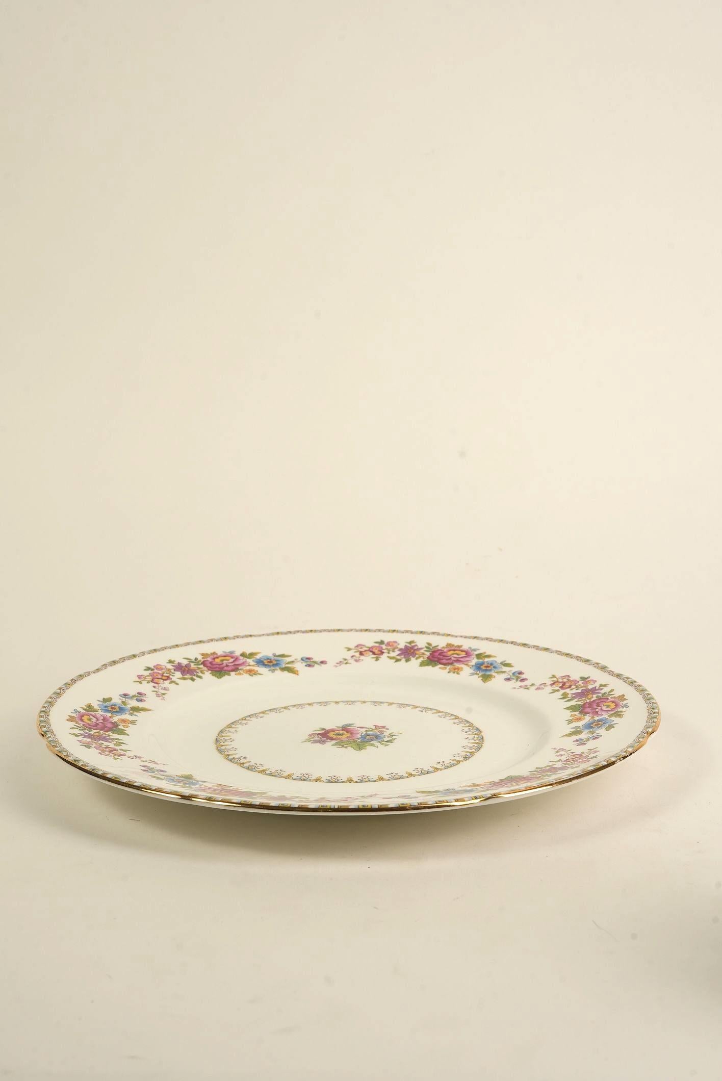 This elegant vintage dinner plate by Royal Grafton features the charming ‘Malvern’ pattern—an exquisite design of multicolored floral sprays arranged around the rim and center of the plate, framed by a fine scalloped edge and delicate gold gilt