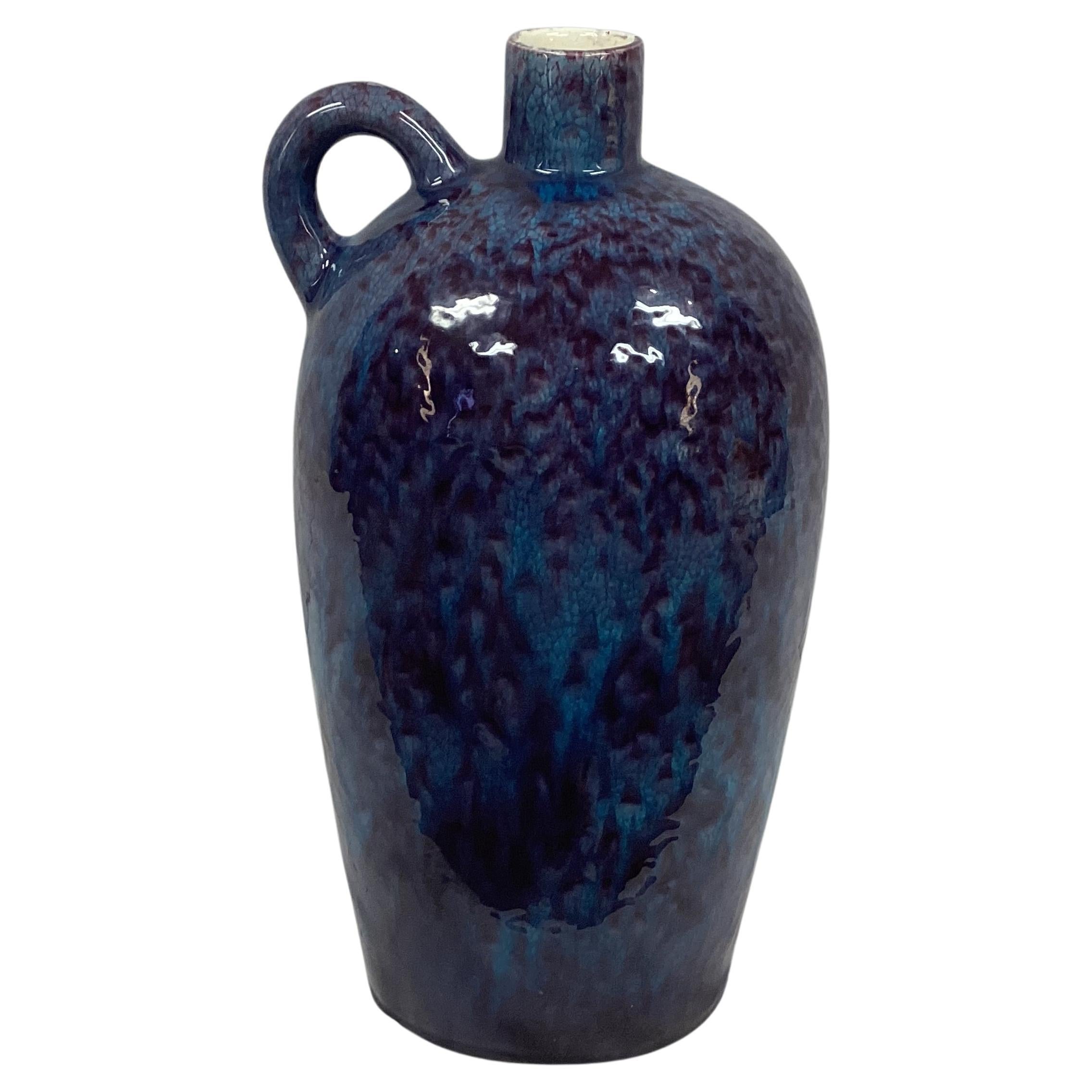 Mid-century Royal Haeger drip glaze pottery vase. Colors featured are rich purple and turquoise. Rounded handle in upper edge of vase. Marked on bottom 
