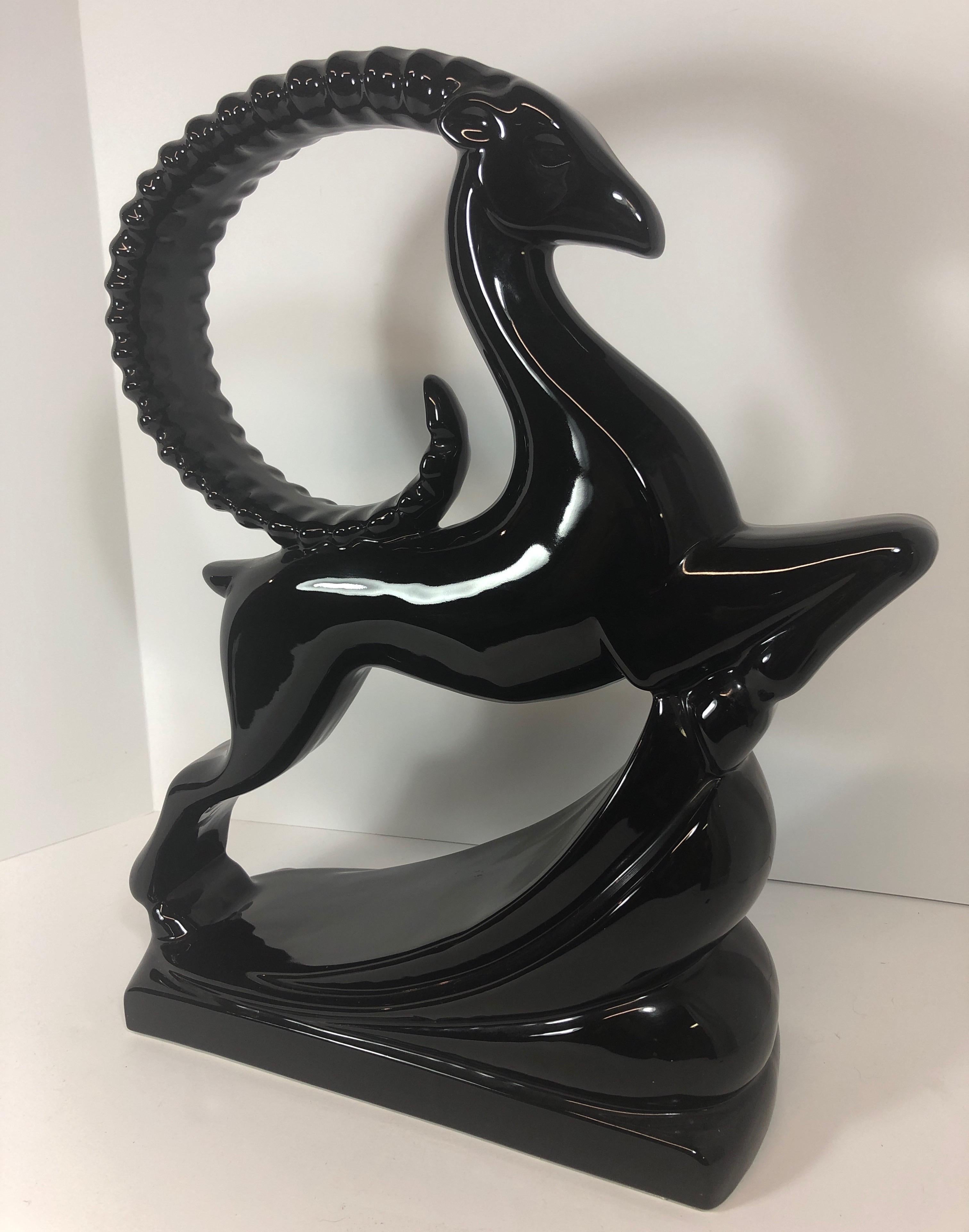 A vintage Art Deco sculpture of an elegant black gazelle in mid-leap, produced by Royal Haeger, circa 1940s-1950s, in glazed ceramic. Markings include original label [Haeger/American Made], on the underside base of the sculpture. Very good vintage