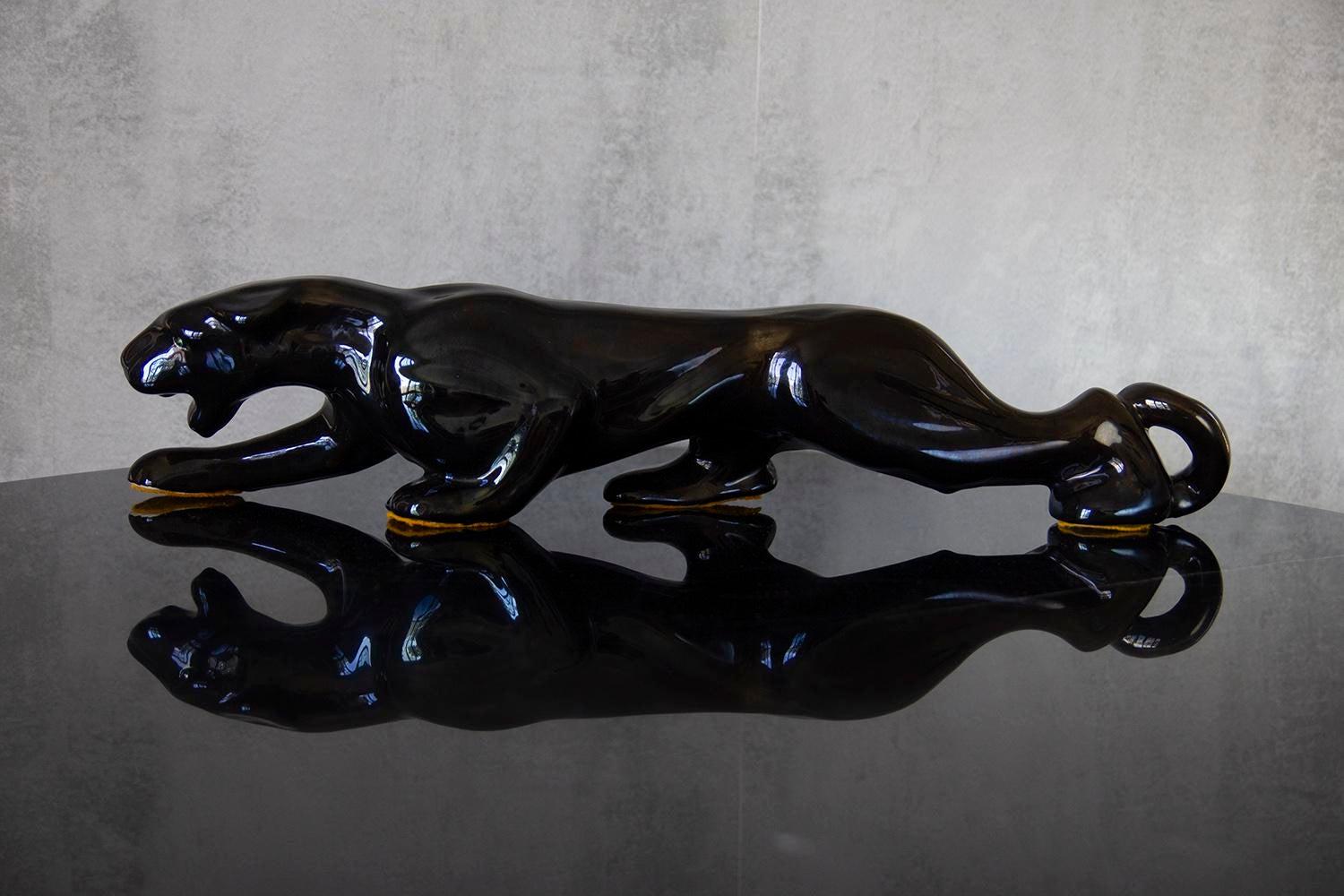 Awesome Mid-Century Modern Royal Haeger style ceramic black panther sculpture with green crystal eyes. Beautiful vintage condition with no cracks, chips, or crazing found. circa 1950s-1960s. This beast is a real beauty. In the style of Royal Haeger.