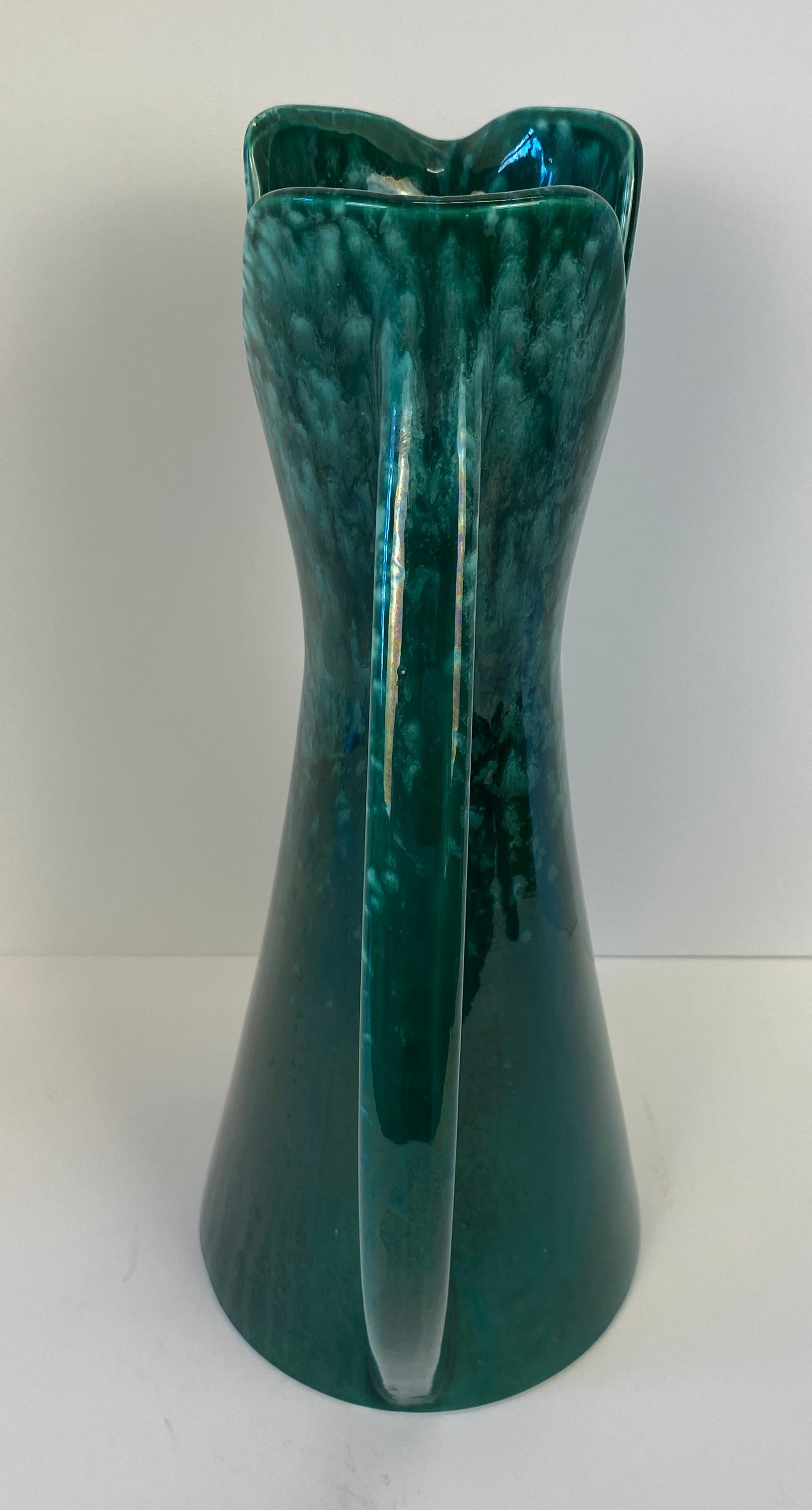 Vaso con manico in ceramica Royal Haeger 

Un vaso in ceramica di ottima qualità realizzato a mano da Royal Haeger. Royal Haeger è una linea di ceramiche artistiche prodotte da Haeger Potteries, nota per gli smalti e i disegni caratteristici, in