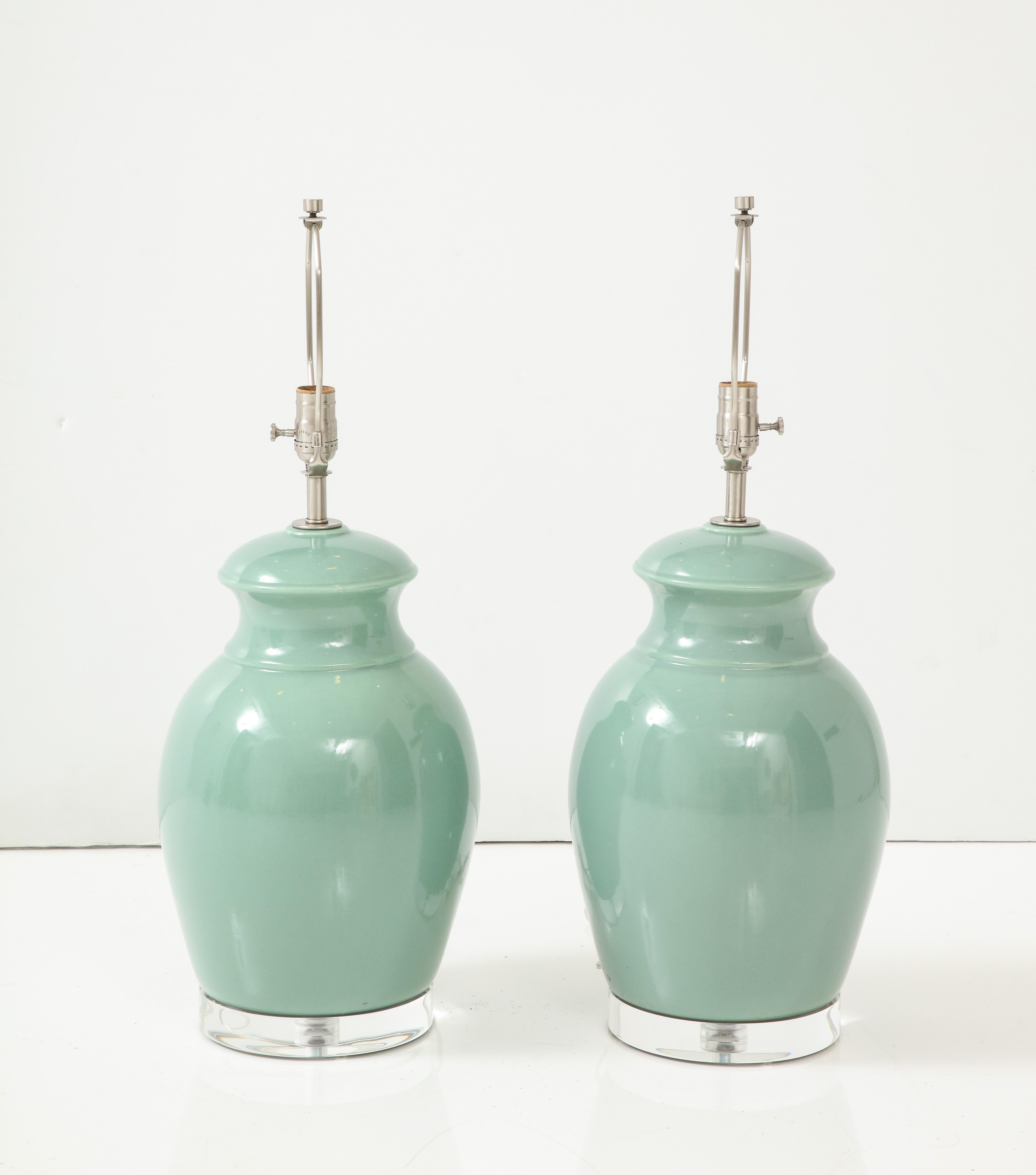 Mid Century pair of ceramic lamps featuring a Turquoise glaze and sitting upon custom Lucite bases. Rewired for use in the USA. 100W bulb max. Lamps rewired by an UL listed electrician using brushed nickel hardware. 