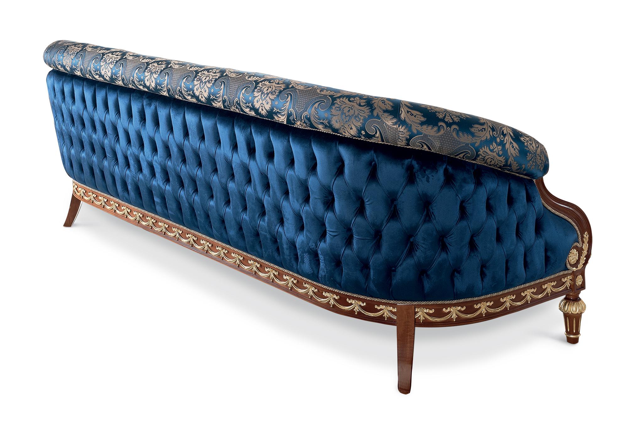 The bespoke noble blue three-seater sofa showcasing the finest work of classic artisanal craft. The curved seat welcomes its guests with two unique design features. Firstly, the stunning damask front upholstered with thick padding. Secondly, the