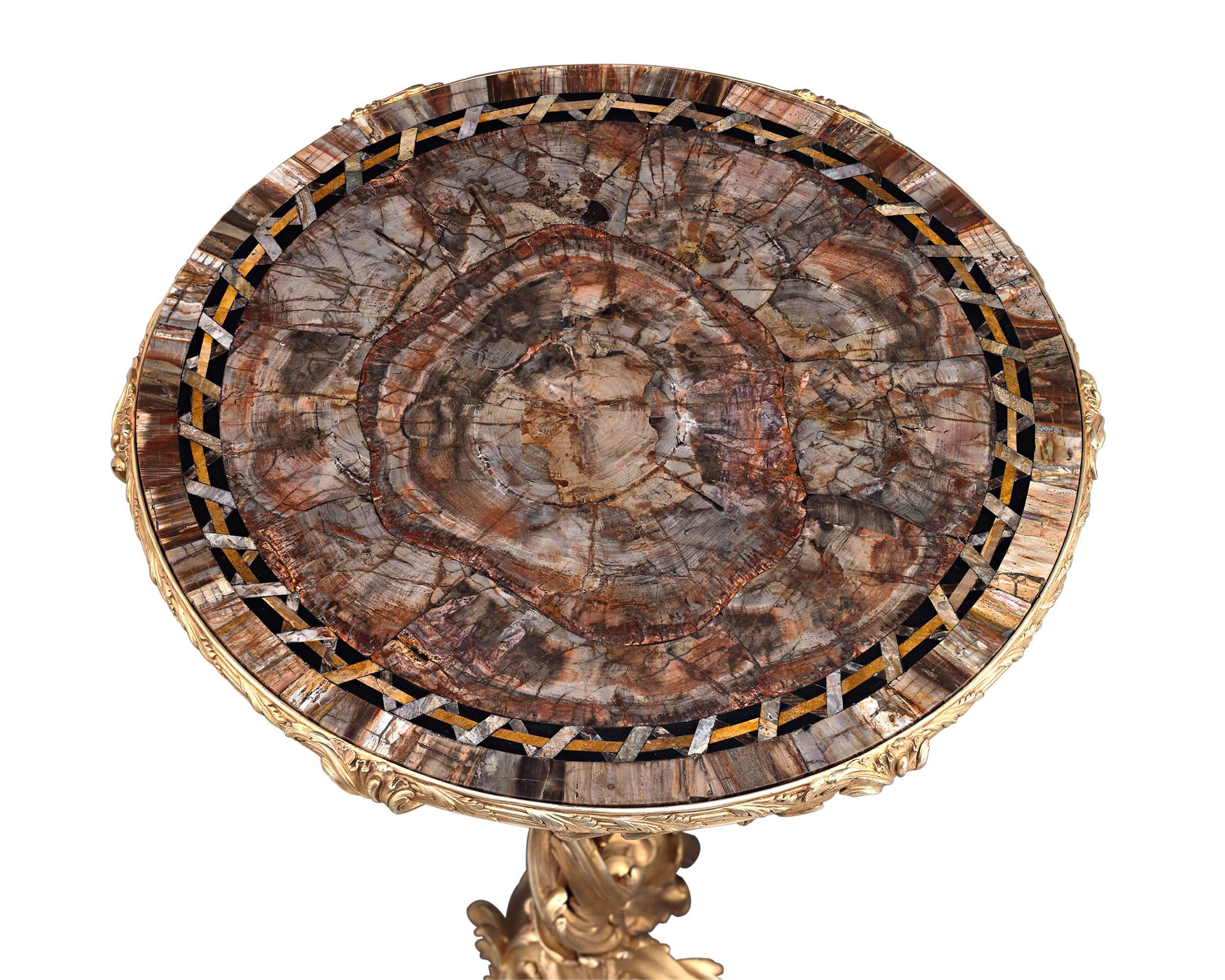 A phenomenal museum-quality masterwork gifted by France’s King Louis XV to a titled European family, this guéridon table features an immensely rare petrified wood surface set into a resplendent Rococo gilt bronze base.

The guéridon’s creation is