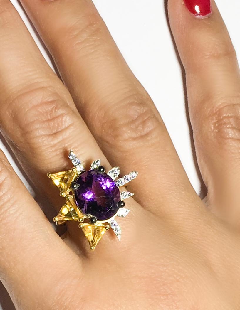 100% Recycled 14K Yellow gold, One oval amethyst (10x12mm/ 0.393×0.472 inches), Twelve white diamonds of approximate total 0,18 carats, Three triangle citrines. 
Yellow gold gemstone ring with amethyst, diamond, citrine.

It is purple and it is